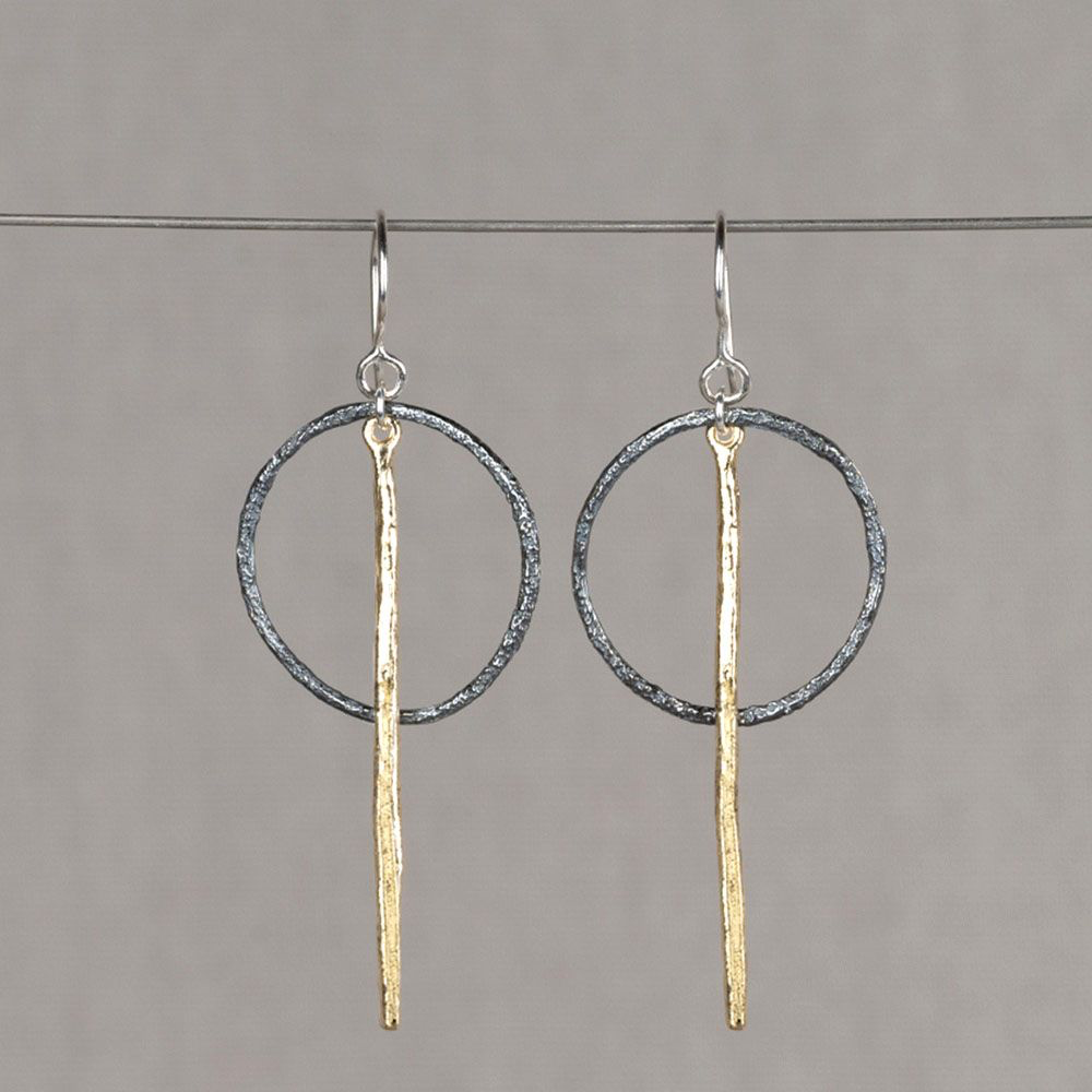 Bijzondere oorhangers gemaakt van een geoxideerd zilveren cirkel en een verguld zilveren pin.