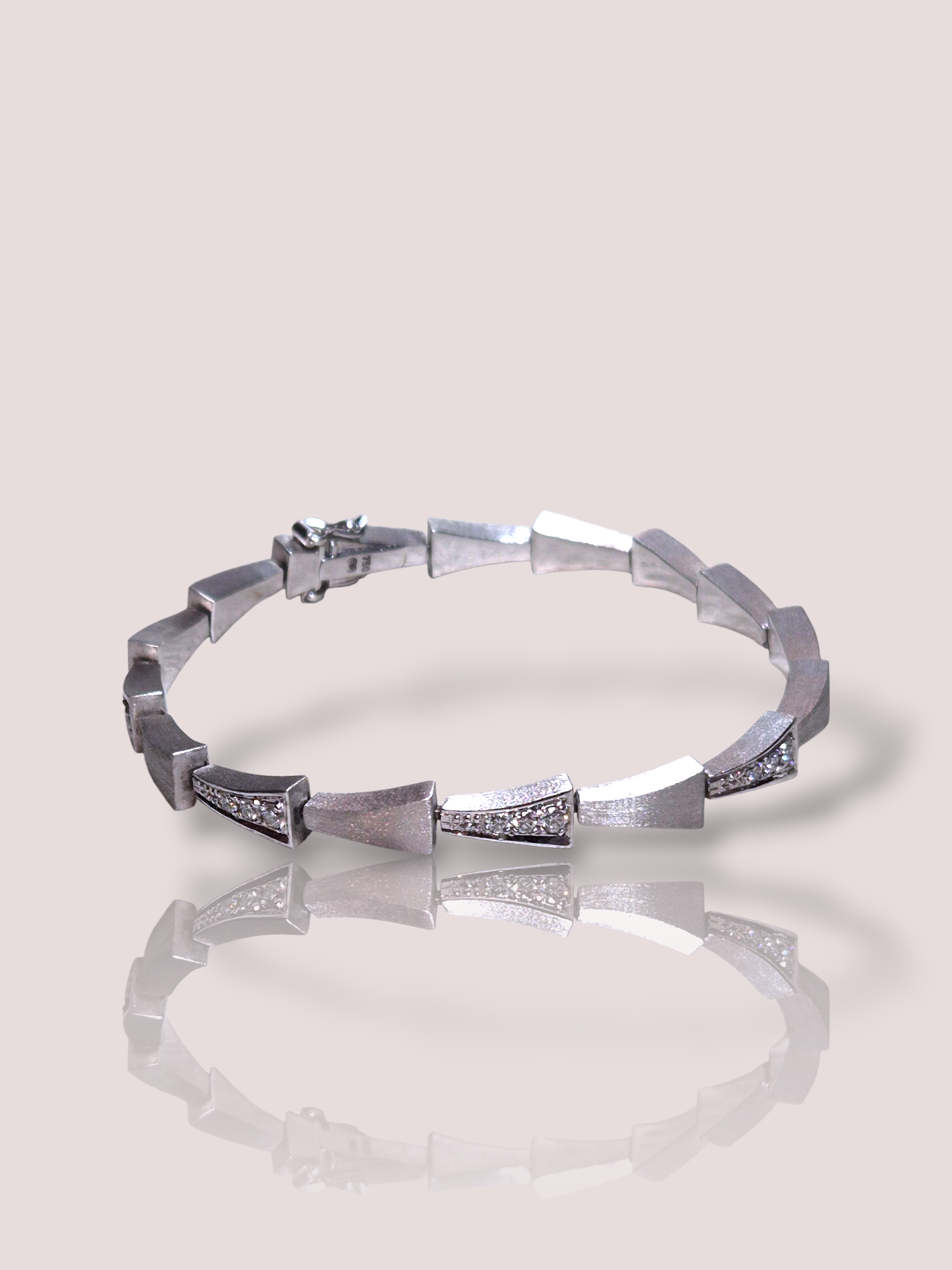 Deze Vintage 18k witgouden armband met diamanten, straalt tijdloze elegantie uit. Deze armband, gemaakt van witgoud, is perfect voor elke speciale gelegenheid. Draag deze verfijnde armband solo voor een subtiele uitstraling of combineer met andere sieraden voor een rijke, luxueuze look. Voeg een vleugje glamour toe aan elke outfit!

Het goud is prachtig bewerkt met een matte afwerking, de 24 diamanten varieren van 0,06ct tot 0,025 ct en hebben een gezamenlijk gewicht van bijna 1ct.