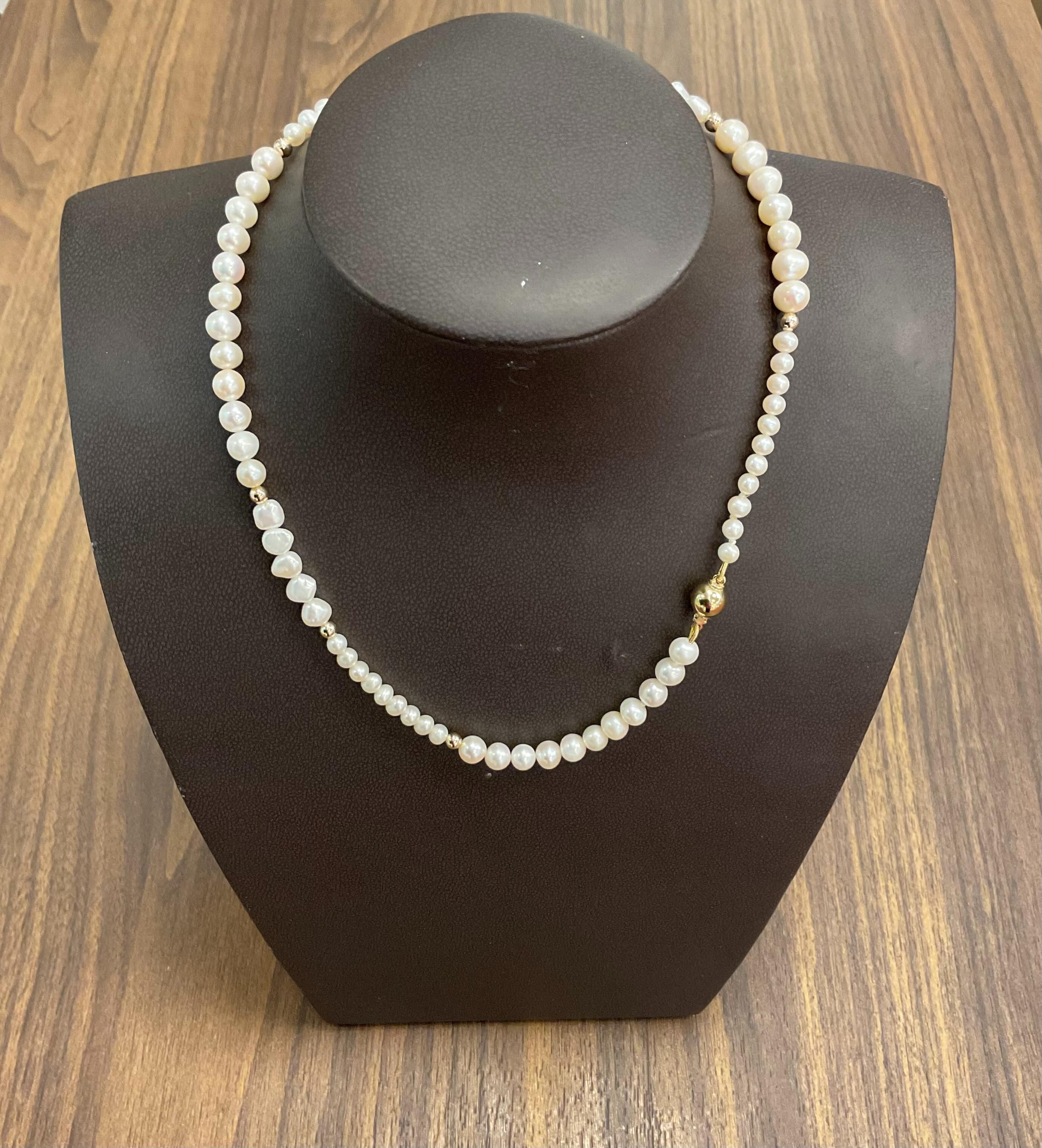 Het Zoetwater parelcollier is voorzien van parels in verschillende afmetingen en double bolletjes, handgemaakt in ons eigen atelier. Met zijn elegante ontwerp is dit collier een verfijnde keuze voor elke gelegenheid. Draag het collier met een eenvoudige zwarte jurk of een klassieke blouse voor een tijdloze en chique uitstraling.