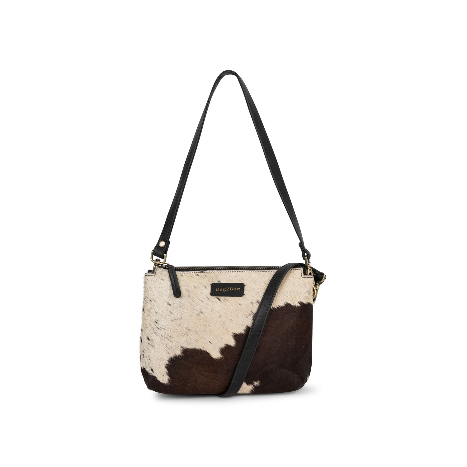 De Sintra is een compacte en trendy crossbody tas, afgewerkt met een unieke voorkant van koeienhuid. Elke tas heeft zijn eigen patroon en is daardoor altijd één van een soort.

De tas heeft een hoofdvak met rits en meerdere vakken binnenin om je essentials overzichtelijk op te bergen. Op de achterkant vind je een extra ritsvak. De verstelbare schouderband zorgt voor optimaal draagcomfort, terwijl de leren details en het stijlvolle design de tas een moderne uitstraling geven.