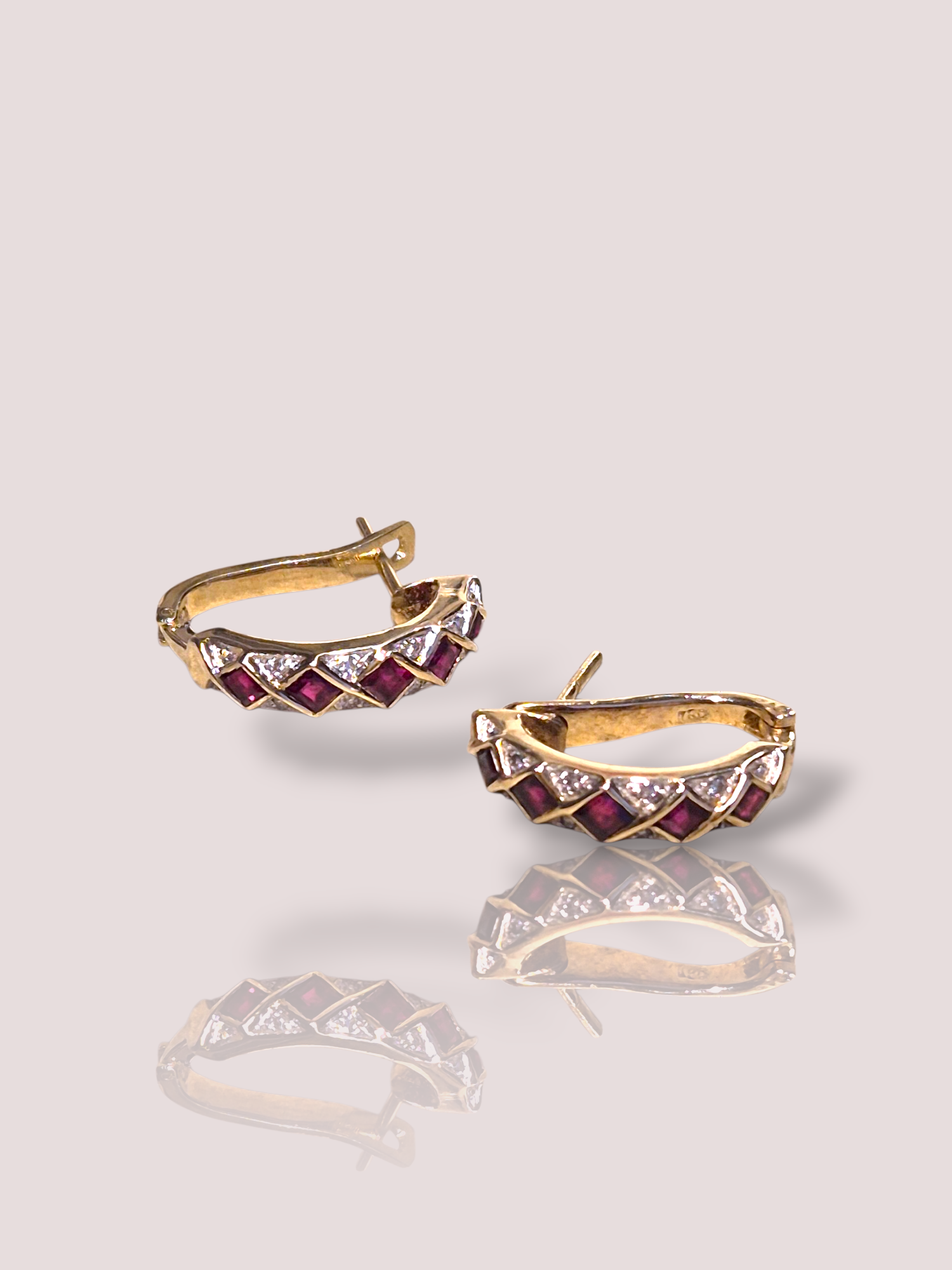 Deze prachtige Vintage 18k geelgouden oorbellen met robijn en diamant zijn een verfijnde toevoeging aan elke sieradencollectie. Als elegante oorbellen passen ze perfect bij zowel formele als informele gelegenheden. Draag ze als opvallend accessoire bij een opgestoken kapsel of eenvoudige outfit voor een klassieke look. 

De oorbellen bevatten samen 10 princess cut geslepen robijnen en 16 briljant geslepen diamanten van samen 0,08ct.