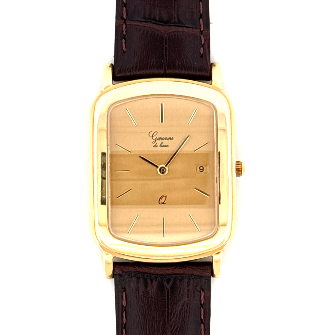 De Garonne de Luxe Horloge 14krt Geelgoud, modelnummer GARONNE 1960WEIS6, is een elegante polshorloge met een gouden rechthoekige kast en een bruin, echt lederen bandje. Het horloge heeft een Zwitserse beweging, datumfunctie, kristallen glas en een gestreept goudkleurig wijzerplaat. Ideaal te dragen bij formele gelegenheden voor een verfijnde uitstraling. 

Categorie: Horloges  
Type: Polshorloge  
Afmetingen: 27mm  
Materiaal band: Echt leer  
Kleur band: Bruin  
Materiaal kast: Goud  
Kleur kast: Goudkleurig  
Vorm kast: Rechthoek  
Dikte kast: 6mm  
Glas: Kristal  
Wijzerplaat kleur: Goudkleurig  
Wijzerplaat patroon: Strepen  
Datumfunctie: Ja  
Beweging: Zwitsers  
Toestand: Nieuw  
