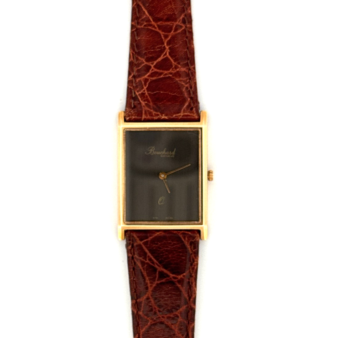 De Bouchard Geneve Horloge 14krt Geekgoud 10157020 is een verfijnd polshorloge met een rechthoekige, goudkleurige kast van 14-karaats goud. Het horloge beschikt over een zwart analoog wijzerplaat en een bruine leren band. Het Zwitserse quartz-uurwerk garandeert nauwkeurigheid. Draag bij formele gelegenheden voor een elegante uitstraling. Het horloge heeft geen datumaanduiding en is nieuw.