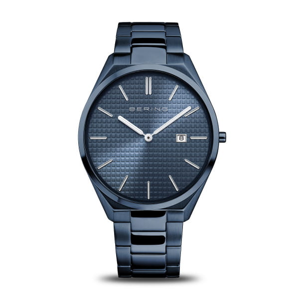  Dit herenhorloge uit de Ultra Slim-collectie is een statement van moderne ingetogenheid &ndash; en bewijst dat elegantie geen woorden nodig heeft. Met een kastdikte van slechts 6 mm behoort het tot de slankste modellen van BERING. Het volledig blauwe ontwerp &ndash; van de kast tot de fijn afgewerkte roestvrijstalen band &ndash; cre&euml;ert een fascinerende monochrome esthetiek met strakke lijnen en een architecturale uitstraling.  De gestructureerde sunray-wijzerplaat in ton-sur-ton weerkaatst het licht in wisselende nuances en geeft het horloge diepte en beweging. Slanke indexen, een subtiele datumaanduiding op drie uur en het platte, krasbestendige saffierglas benadrukken het streven naar functionele helderheid en minimalistisch design. Binnenin zorgt een nauwkeurig quartz uurwerk voor betrouwbare tijdsweergave &ndash; minimalistisch in stijl, maximaal in effect.  Met een waterdichtheid van 3 ATM en een veilige vouwsluiting is dit horloge de ideale metgezel voor mannen die tijdloos design en moderne subtiliteit weten te waarderen. 