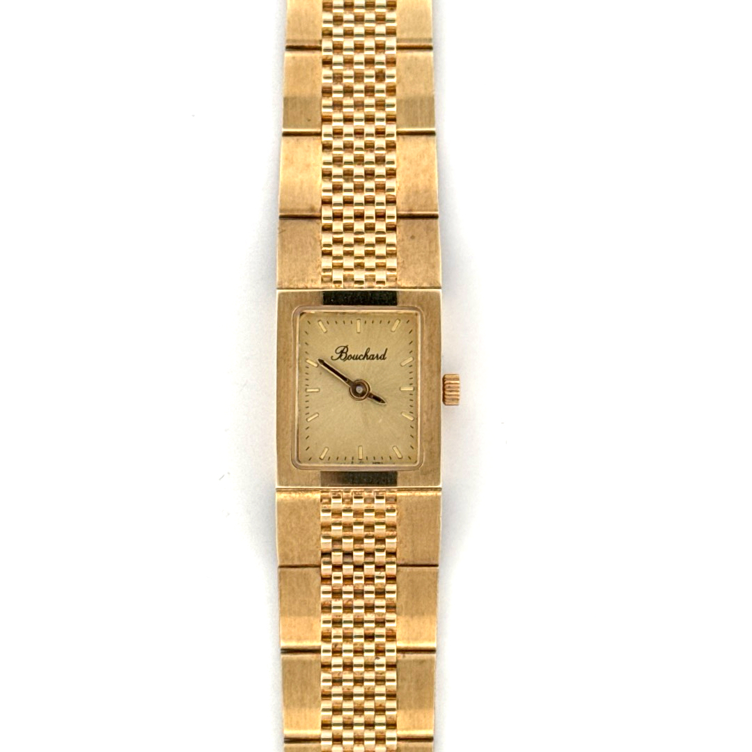 De Bouchard Horloge 14krt Geelgoud 1135308 is een elegante polshorloge met een rechthoekige gouden kast en saffierglas. Het horloge heeft een analoge tijdsaanduiding en een quartz uurwerk met Zwitserse precisie. De gouden wijzerplaat met streepjesindexen maakt het ontwerp compleet. Draag dit luxe horloge bij formele gelegenheden voor een verfijnde en stijlvolle uitstraling.