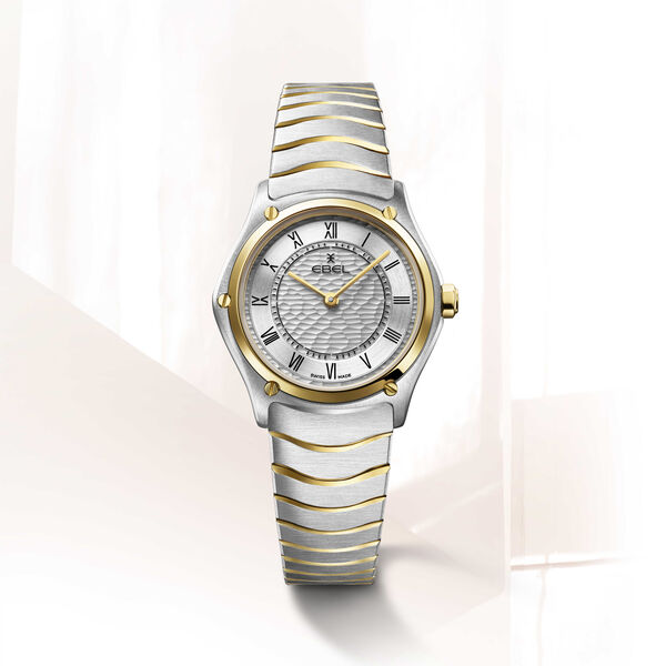 De Ebel horloge 1216697 combineert elegantie en functionaliteit. Dit luxe polshorloge heeft een goud-zilver kleurige, anti-allergische roestvrijstalen band met studs, een analoge wijzerplaat met Romeinse cijfers en een Zwitserse kwartsbeweging. Dit horloge is 5 ATM waterbestendig en heeft een saffier gecoat glas. Perfect voor dagelijks gebruik en speciale gelegenheden. Draag hem bij formele en casual outfits.
