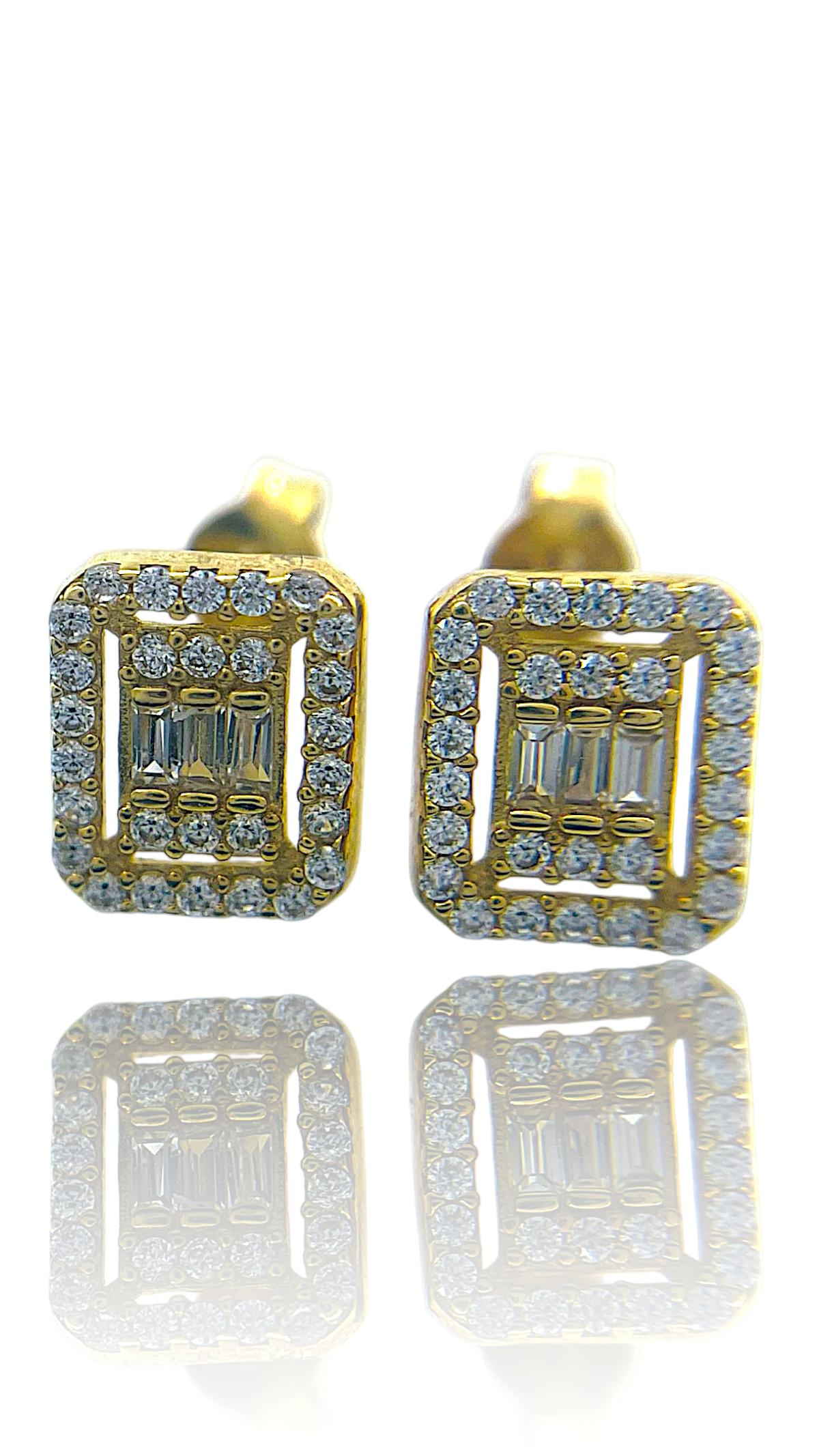 Deze prachtige oorknoppen, zijn vervaardigd uit 14-karaats geelgoud en hebben een schitterende baguette zirkonia, omringd door briljant geslepen zirkonia's. Perfect voor een verfijnde en toch opvallende look, ideaal voor zowel dagelijkse outfits als speciale gelegenheden. Draag ze met je favoriete gele of gouden sieraden voor een harmonieuze uitstraling.