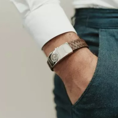 Zilveren armband met lederen bandje. Bovenop het zilveren stuk kan de armband gevuld worden met as of haar. De lederen band is verkrijgbaar in diverse kleuren en wordt voor u op de juiste polsmaat gemaakt.

Door op het as-compartiment te drukken opent u het slot. Op het slot is nog genoeg ruimte om bijvoorbeeld een tekst, handtekening of vingerafdruk op te laseren.