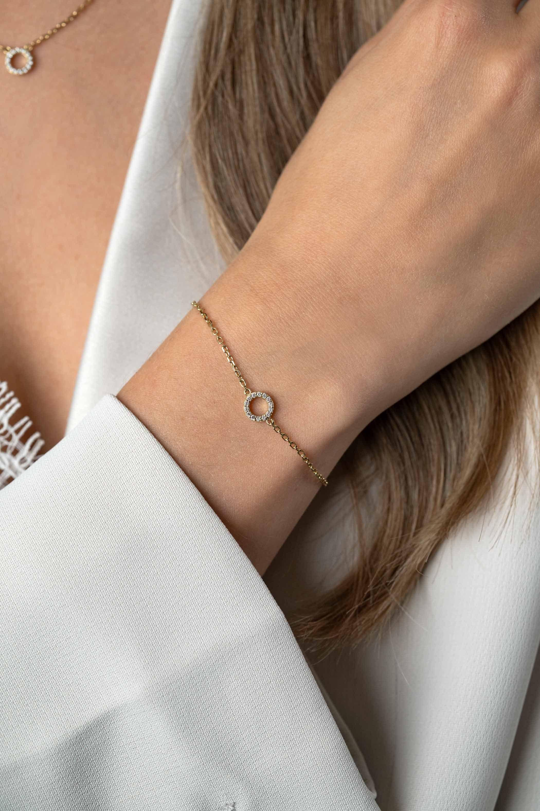 ZINZI gold plated zilveren armband met subtiele paperclip schakel en open rondje (7,5mm). Het rondje in het midden van de armband is mooi bezet met witte zirconia's. Een sierlijke armband die ook goed te combineren is met andere zilveren armbanden. Met herkenbaar Zinzi hartje bij de sluiting. De lengte is te variëren tussen 16,5 en 19,5 cm. De armband is vervaardigd van eerste gehalte zilver (925) en extra geel verguld.