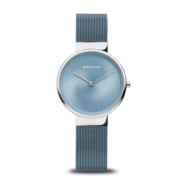  Dit dameshorloge uit de Classic-collectie van BERING fascineert met een wijzerplaat die het oog vangt als een draaikolk van licht en kleur. De fijn gegraveerde spiraal op de blauwe sunray-afwerking cre&euml;ert bij elke beweging een hypnotisch gevoel van diepte &ndash; ge&iuml;nspireerd op de structuren van bevroren water en het spel van licht op Arctisch ijs.  De gepolijste kast van roestvrij staal in koel zilver omlijst het ontwerp met minimalistische elegantie. Het fijnmazige blauwe Milanese bandje sluit soepel om de pols en zorgt voor een aangenaam draagcomfort. De wijzerplaat wordt beschermd door een plat, krasbestendig saffierglas &ndash; helder, duurzaam en verfijnd.  Aangedreven door een betrouwbaar quartz uurwerk en waterbestendig tot 3 ATM, is dit horloge niet alleen een stijlvol designelement, maar ook een elegante metgezel voor elke dag. 