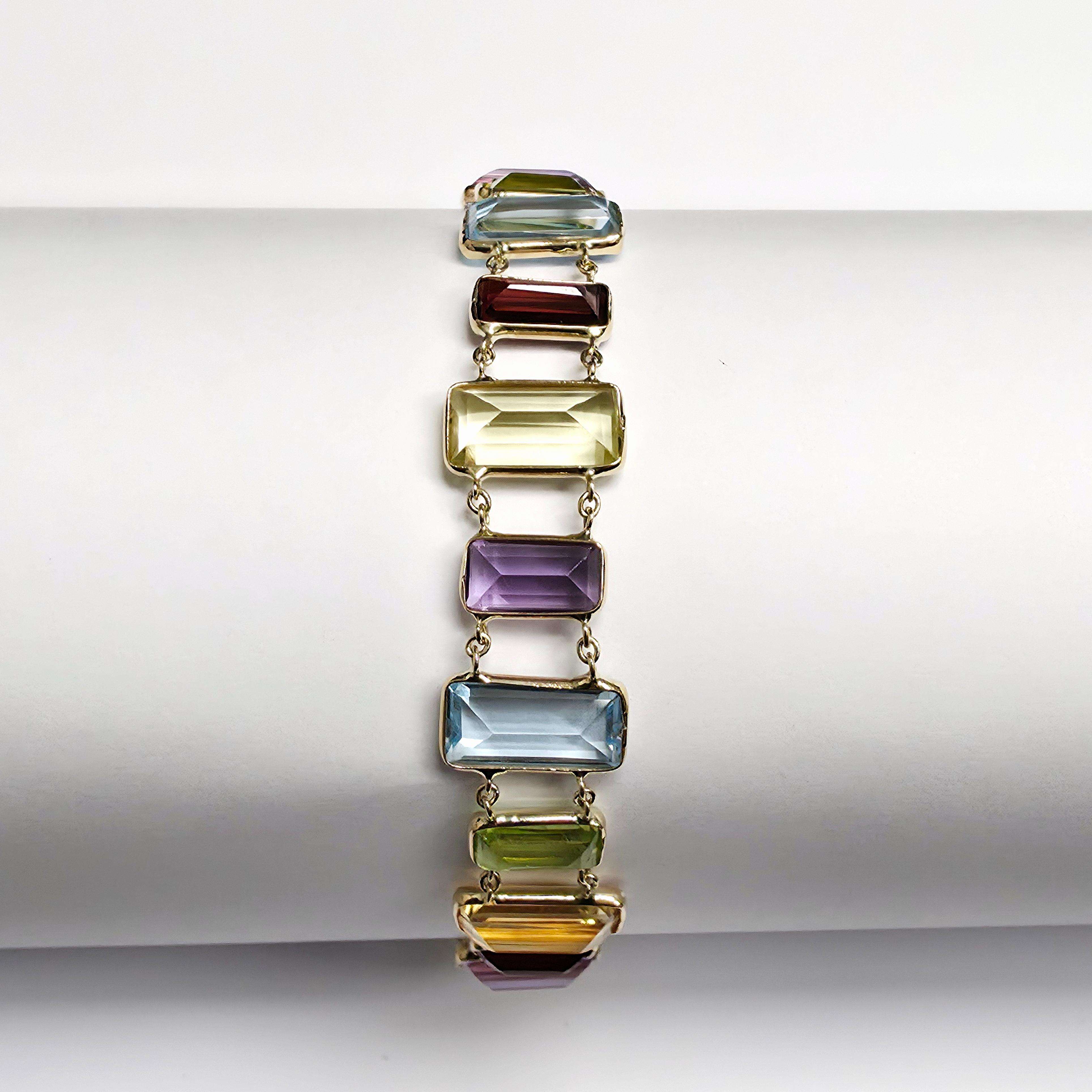 Prachtige gouden armband met verschillende kleuren edelsteen.