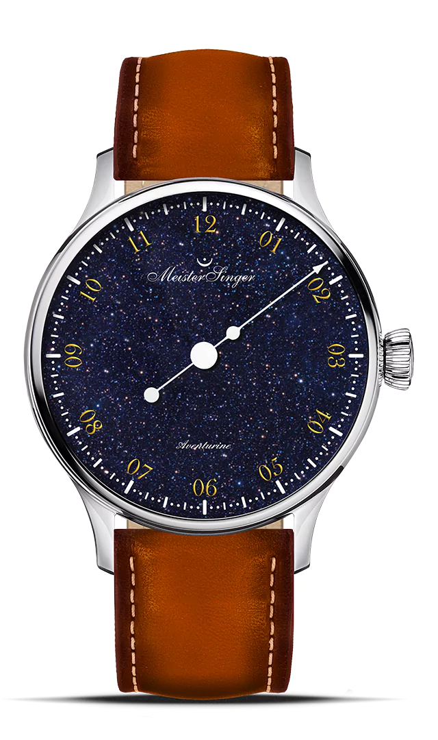 De diepblauwe steen uit de kwartsfamilie fascineert het oog met zijn karakteristieke glans, die wordt gecreëerd door fijn verspreide minerale insluitsels. Deze reflecteren het licht en creëren de zogenaamde aventurescence – een speciale glans met een levendige schittering die elke wijzerplaat uniek maakt. Het typografische ontwerp doet denken aan historische wijzerplaten en geeft het horloge een nostalgisch karakter. De goudkleurige, meervoudig gedrukte cijfers springen er levendig uit en creëren een elegant, driedimensionaal effect. In plaats van de gebruikelijke 5-minuten streepjes, markeren fijne puntjes het verstrijken van de tijd. Het ontwerp wordt gecompleteerd door de kunstzinnig vormgegeven MeisterSinger-uurwijzer, die doet denken aan een tijdperk waarin horloges nog aan een ketting werden gedragen.
