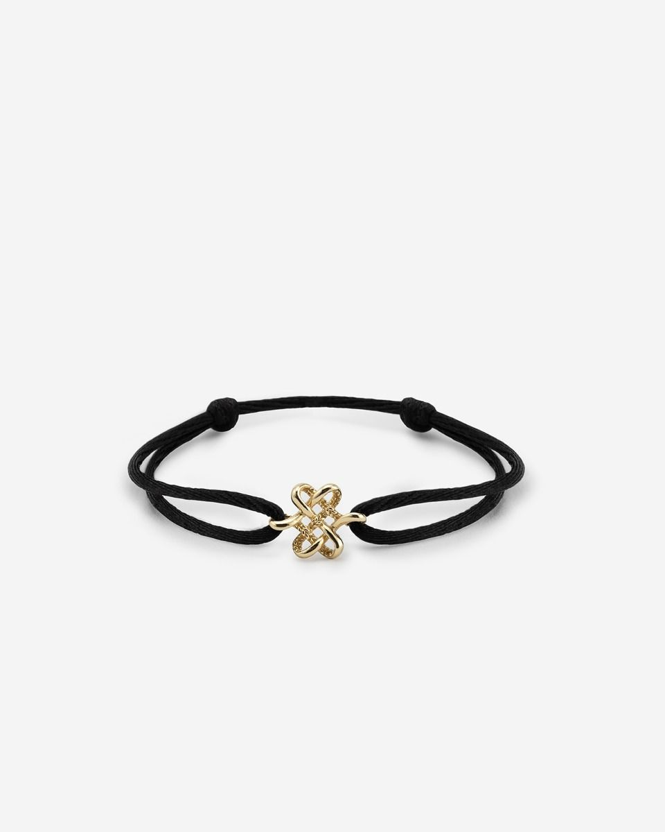 De Endless Knot Koord Armband van 14-karaat goud; een altijd aanwezig aandenken aan grenzeloze liefde, voorzien van een complex gevlochten knoop die oneindig in een lus loopt. Liefde en toewijding verweven in een tijdloos stuk. De finishing touch is een verstelbaar koord, dat zorgt voor een naadloze, op maat afgestelde pasvorm. Zorgvuldig ontworpen in Amsterdam en met de hand gemaakt in Zuidoost-Azi&euml;, viert de Endless Knot de onafscheidelijke band tussen jou en een speciaal iemand.