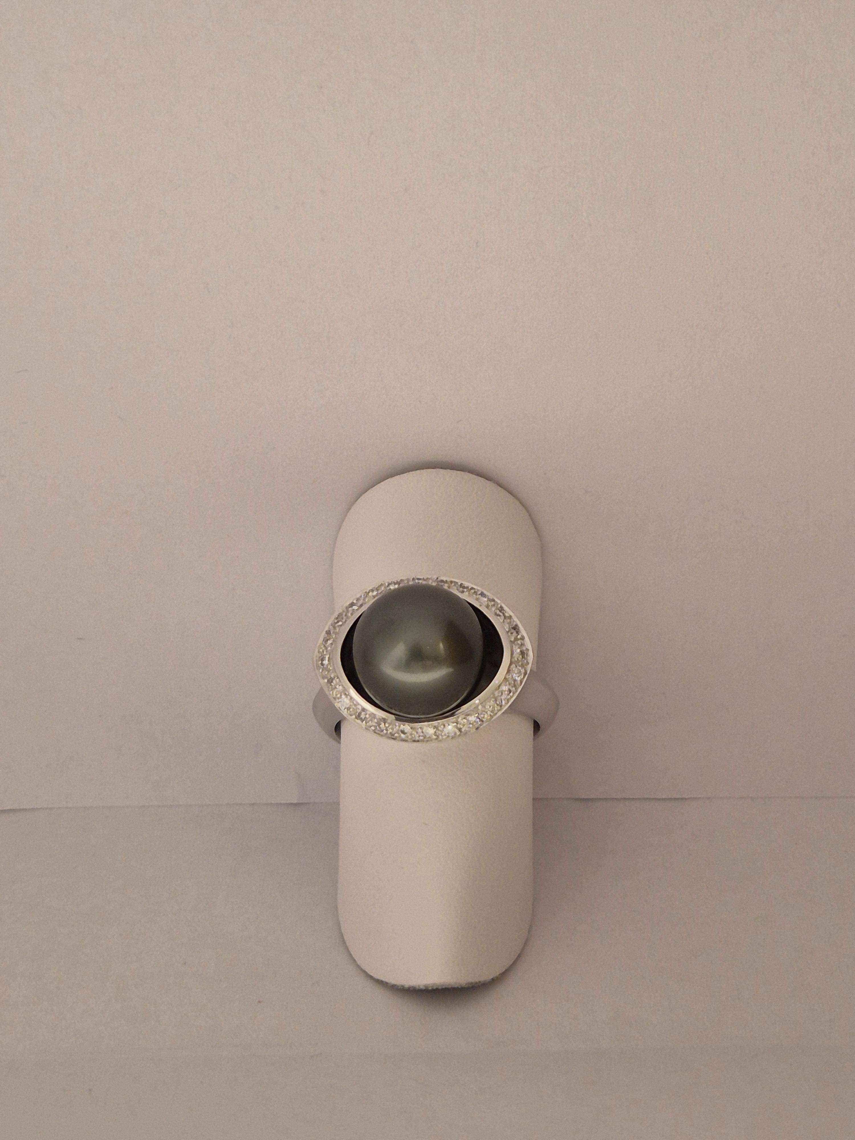 Deze prachtige 18-karaats witgouden ring, model heeft 24 briljant geslepen diamanten (0.17ct) en een elegante grijze parel, perfect voor speciale gelegenheden. Het beste te dragen op ringmaat 54, als statement piece of combineer met andere sieraden voor een verfijnde look. Een tijdloze toevoeging aan elke juwelen collectie.