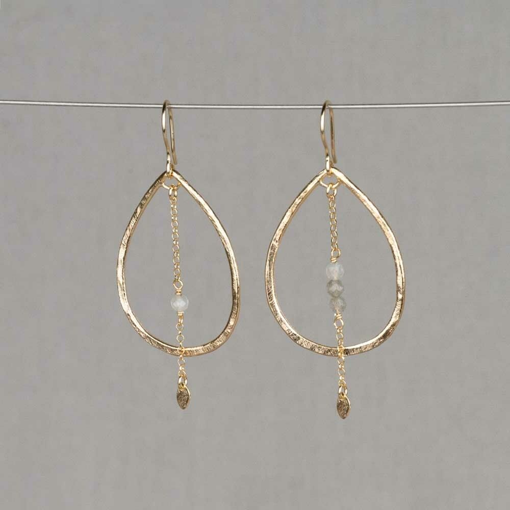 Oorbellen gemaakt van zilver verguld met daaraan een slinger met Labradoriet. De oorbellen zijn asymmetrisch, aan de ene oorbel hangt een slinger met 1 steen en aan de andere 3 stenen. Dit maakt het sieraad uniek en speels! Combineer deze oorbellen met een mooi collier, een ring en armband voor een complete look!