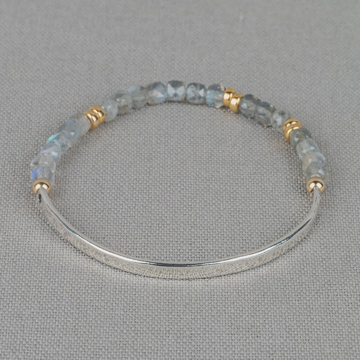 Armband gemaakt van 925 sterling zilver in combinatie met Goldfilled balletjes en de edelsteen Labradoriet. Deze armband is voor de helft gemaakt van een zilveren bangle armband en de andere helft zijn edelstenen. Door middel van het elastiek wat gebruikt is, kun je de armband gemakkelijk om en af doen. 