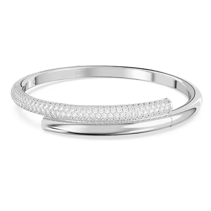 Deze gekruiste armband met een elegante lus om de pols zorgt voor een maximale impact. Het tubulaire ontwerp biedt de perfecte combinatie van klassieke en moderne stijlen, met een band met een rhodium toplaag die half is gedecoreerd met all-over helder swarovski kristallen. De armband is voorzien van een verborgen magneetsluiting, voor een perfecte afwerking. Een luxueus sieraad dat elke outfit die u draagt nog specialer maakt.