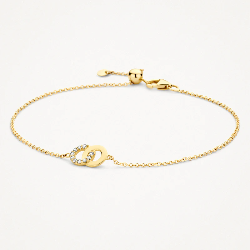 Bij deze bijzondere 14k geelgouden armband grijpen twee ringen in elkaar. Een van de ringen is bezet met zirkonia’s die gezet zijn in een pavé zetting. De armband  heeft een totale lengte van 18cm. Een prachtig sieraad om cadeau te doen aan een geliefde of aan jezelf. Draag de armband samen met het bijpassende collier.