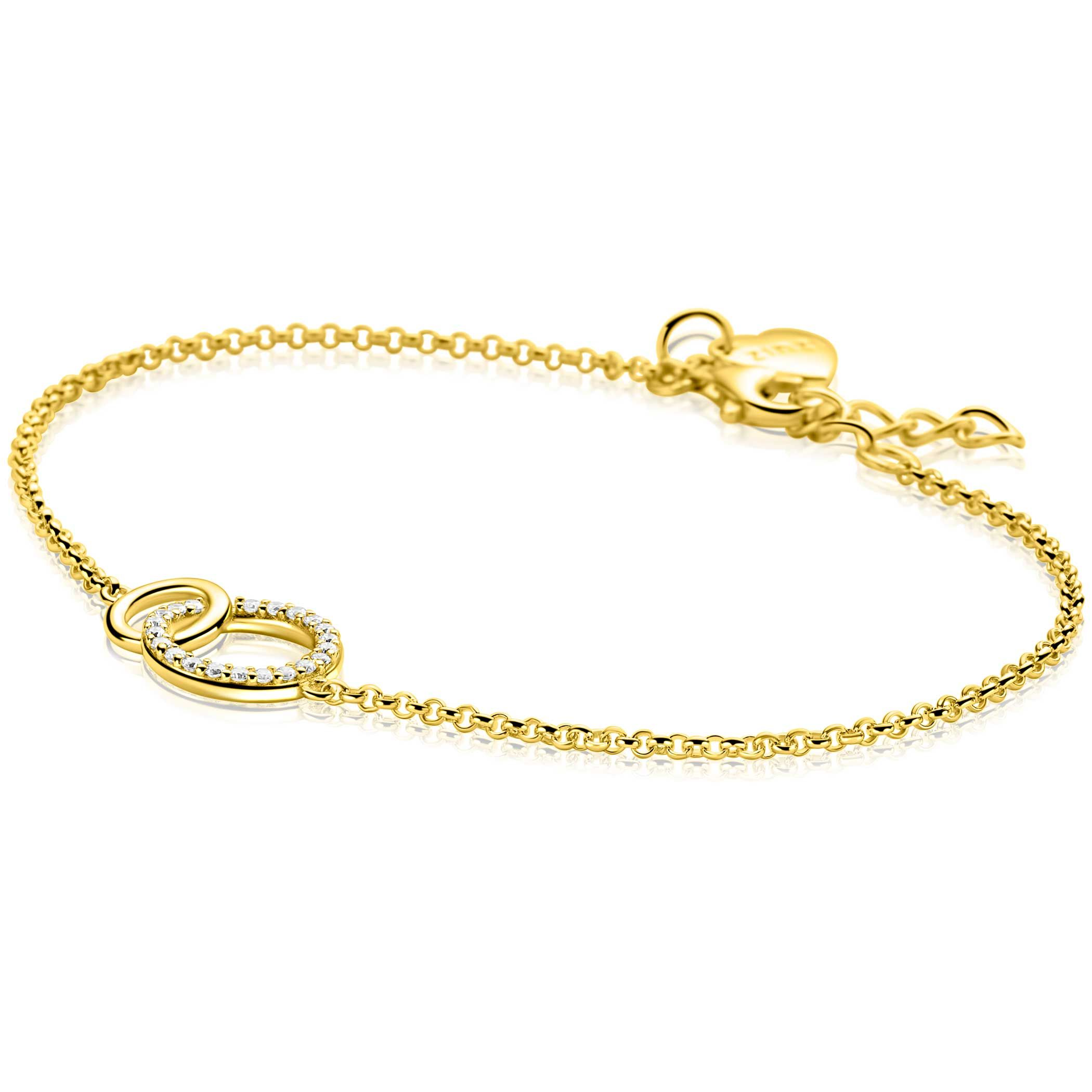 ZINZI goldplated zilveren trendy armband, waarbij in het midden twee open vormen mooi met elkaar verbonden zijn: een glad open rondje en een groter open rondje bezet met witte zirconia's. De lengte is te variëren tussen 18 en 20cm. Met herkenbaar Zinzi hartje bij de sluiting. Vervaardigd van eerste gehalte zilver (925) en extra geel verguld.