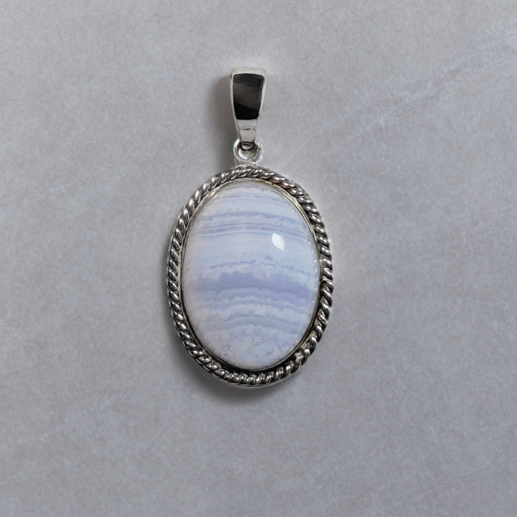 Sterling Zilveren hanger met getordeerde rand en een ovaal cabochon geslepen blauw kant agaat.
De hanger is open aan de achterzijde.