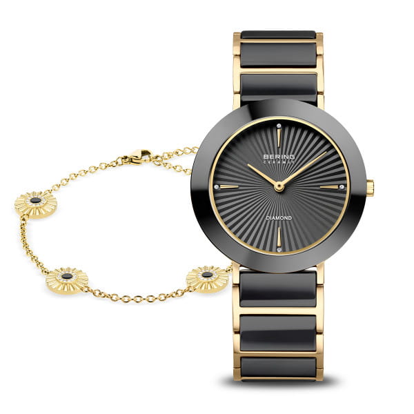  Het BERING dameshorloge 11435-732-GWP combineert diepzwart met warm goud en heldere lijnen in een harmonieus ontwerp. De ronde kast van glanzend zwarte high-tech keramiek wordt omlijst door goudkleurig roestvrij staal &ndash; een moderne, tijdloze combinatie.  Het gestructureerde wijzerplaatpatroon laat fijne lijnen vanuit het midden uitstralen, als zonnestralen. Goudkleurige wijzers en twee Swarovski-kristallen op 6 en 12 uur zorgen voor verfijnde accenten.  Bij dit cadeaupakket hoort ook een elegant armbandje met bloemmotieven en fonkelende steentjes &ndash; perfect afgestemd op het horloge en een blikvanger om elke pols. 