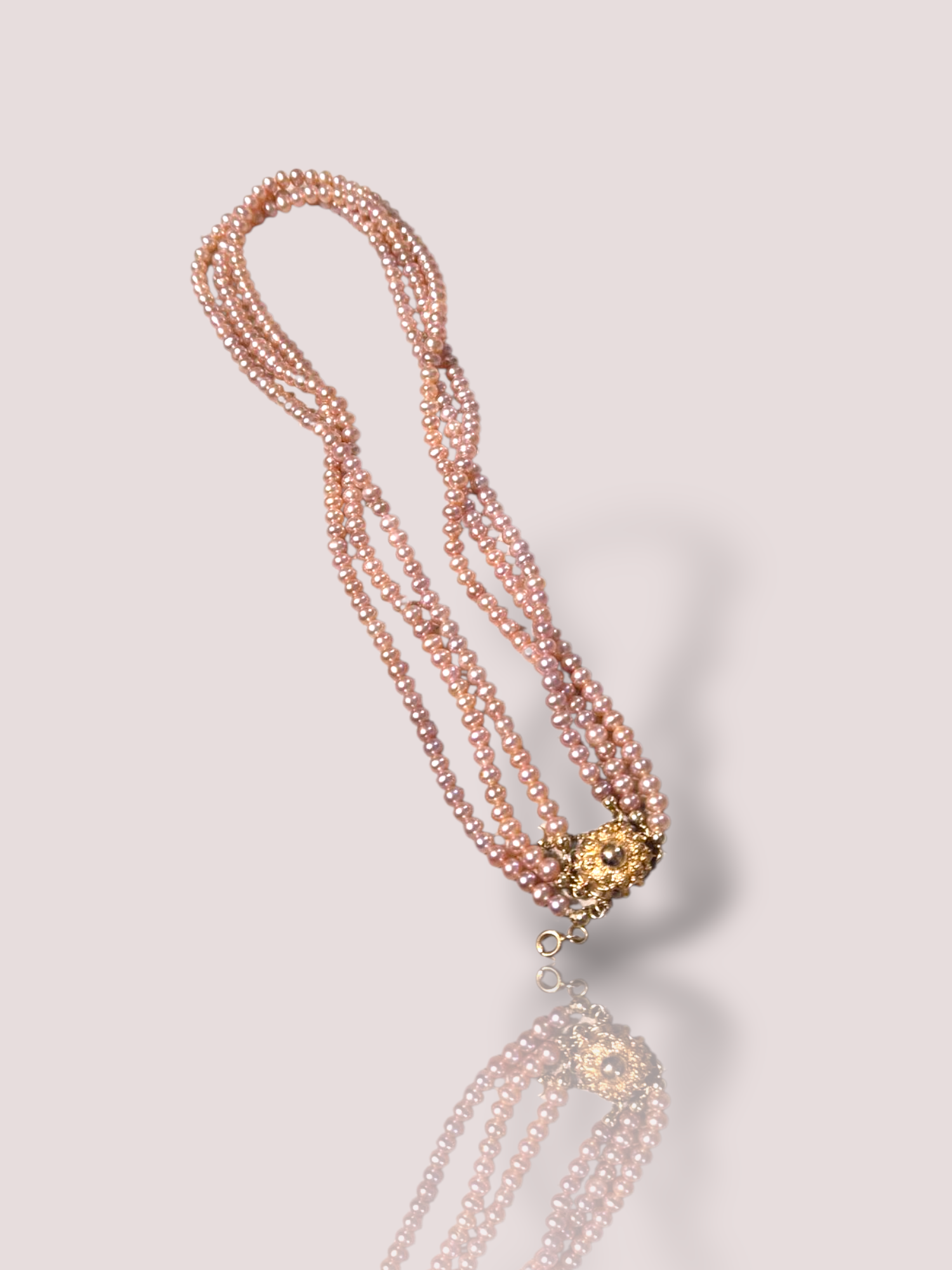 Dit Vintage Zoetwater parelcollier met beschikt over prachtig glanzende rozige parels en een schitterend 14k geelgouden slot. Draag deze elegante ketting solo als een statement piece of combineer met andere delicate kettingen voor een gelaagde look. Perfect voor zowel formele gelegenheden als een chique alledaagse stijl. 

Het collier is 3-rijig waarbij het korste snoer 41 cm is.