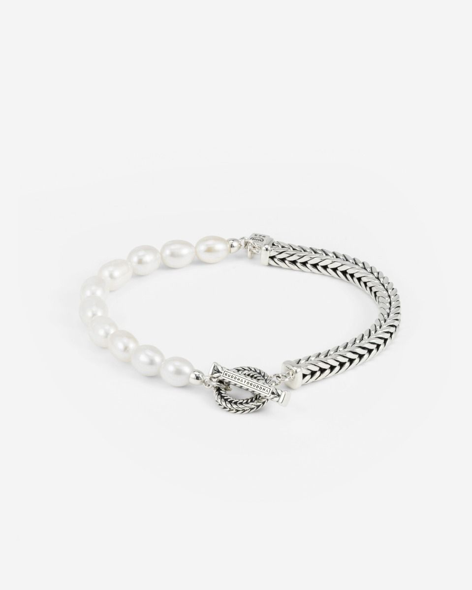 De Barbara Pearl XS armband is de bredere en gedurfdere versie van onze Barbara Pearl Mini armband. Hij biedt een unieke mix van witte ovale zoetwaterparels, gecombineerd met de kenmerkende Barbara-schakel en afgewerkt met een gestructureerde togglesluiting. Dit tijdloze ontwerp is geschikt voor iedereen en combineert moeiteloos met andere items uit de Buddha to Buddha collectie. Een aardende herinnering bij elke stap.