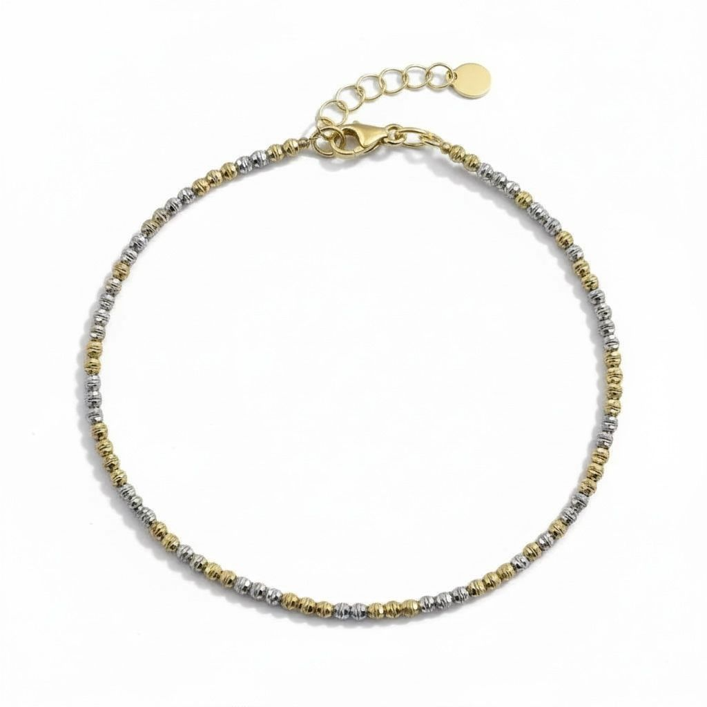 Het Armband Bicolor Ballen is een stijlvol sieraad. Gemaakt van 14 karaat goud en heeft een bicolor ontwerp in goud en witgoud kleuren. De bracelet heeft een breedte van 2 mm en is voorzien van een stevige karabijnsluiting. Perfect voor zowel dagelijks gebruik als speciale gelegenheden. Draag het solo voor een elegante look.