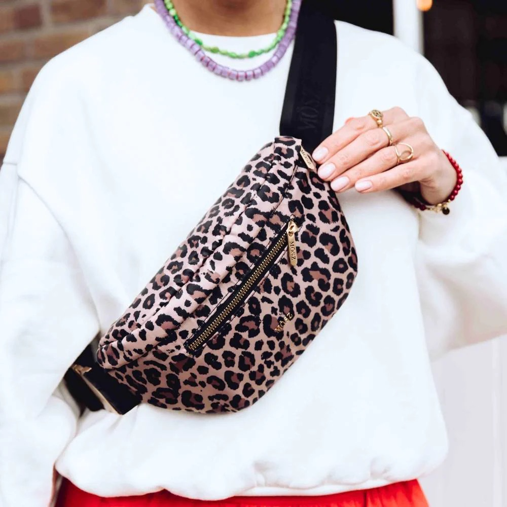 Jessy crossbody heuptas dames – Panterprint | Trendy, speels & superpraktisch

Op zoek naar een tas die stijl, comfort en functionaliteit moeiteloos combineert? De Jessy crossbody heuptas voor dames in panterprint is dé accessoire voor vrouwen die graag een opvallend maar praktisch item dragen. De speelse animalprint maakt elke outfit modieus, of je nu een dagje uit gaat, naar een festival gaat of je dagelijkse essentials slim wilt organiseren.
Speels, veelzijdig & altijd stylish

De Jessy heuptas dames is ontworpen voor maximale flexibiliteit. Dankzij de verstelbare band met subtiel MŌSZ-logo draag je de tas moeiteloos op drie manieren:
✔ Crossbody
✔ Als heuptas
✔ Als schoudertas
Het hoogwaardige, lichtgewicht nylon met levendige panterprint is duurzaam, makkelijk schoon te maken en geeft jouw look direct een trendy boost.
Slimme opbergruimte voor elke dag

De Jessy is compact, maar verrassend ruim ingedeeld. Precies zoals je het van MŌSZ mag verwachten:
Binnenin: een handig vakje voor pasjes en een elastiek voor bijvoorbeeld je lippenbalsem of parfumstick.
Voor- en achterzijde: twee ritsvakken waarin je snel bij je telefoon, sleutels of andere must-haves kunt.
Of je nu reist, shopt, wandelt of een avondje uit gaat: alles wat je nodig hebt blijft overzichtelijk en binnen handbereik.
Waarom kiezen voor de Jessy crossbody heuptas?
✔ Trendy panterprint voor een fashionable statement
✔ Te dragen als crossbody, schoudertas of heuptas
✔ Voorzien van meerdere handige ritsvakken
✔ Gemaakt van lichtgewicht, duurzaam nylon
✔ Ideaal voor festivals, reizen, wandelen of een dagje shoppen

Met de Jessy crossbody heuptas dames in panterprint geef je elke outfit een speelse, stijlvolle upgrade. Compact, handig en heerlijk veelzijdig – precies wat je zoekt in een everyday essential.