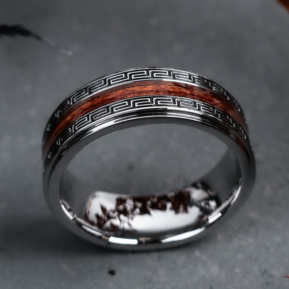 Ontdek onze "Numerary" ring met een hart gemaakt van Hawa&iuml;aans koahout en zilverkleurig roestvrij staal. De speciale coating van het hout garandeert dat dit unieke stuk waterdicht is, terwijl de mysterieuze gravures beelden oproepen van vervlogen tijden en fantastische wezens.