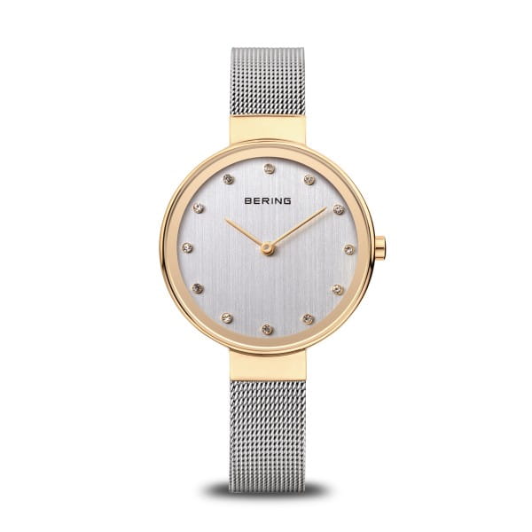  Subtiele glans &ndash; een modern sieraad met een gouden accent  Dit dameshorloge uit de Classic collectie van BERING combineert Scandinavisch minimalisme met een vleugje glamour. De geborstelde zilverkleurige wijzerplaat straalt rust en verfijning uit, verrijkt met sprankelende kristallen als uurmarkeringen &ndash; als zonlicht op ijs, subtiel maar betoverend.  De ronde kast van 34 mm is gemaakt van roestvrij staal en voorzien van een glanzende IP-gouden coating, die warmte toevoegt aan het koele, moderne ontwerp. Plat saffierglas beschermt tegen krassen, en het nauwkeurige quartz uurwerk garandeert betrouwbare tijdweergave.  De zilverkleurige Milanese band sluit elegant om de pols en is voorzien van een praktische klapsluiting. De combinatie van zilver en goud zorgt voor een tijdloze uitstraling &ndash; perfect voor dagelijks gebruik of bijzondere gelegenheden.  Met een waterdichtheid tot 3 ATM is dit horloge jouw stijlvolle metgezel &ndash; dag in, dag uit. 