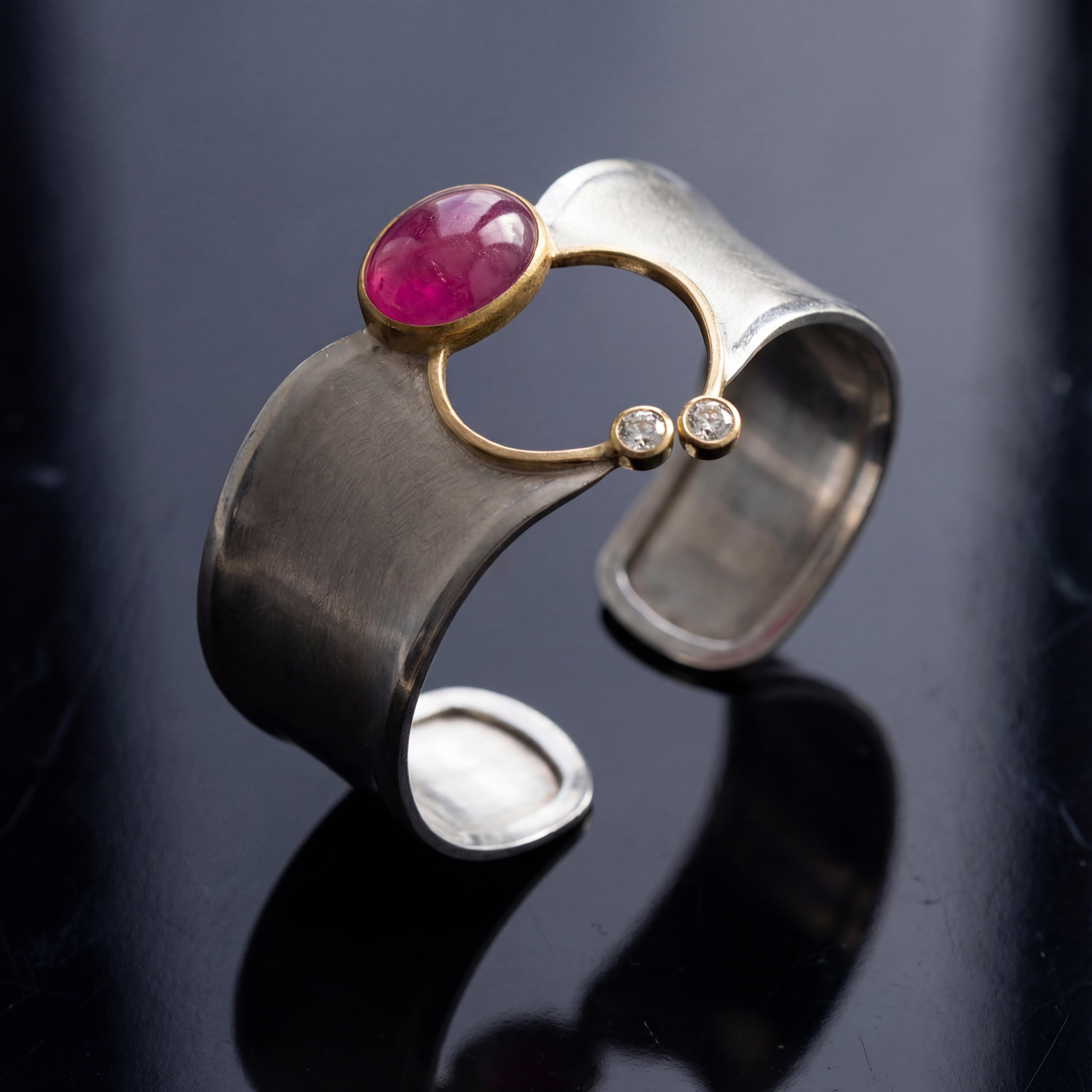 Diese  exquisite Platinarmspange kombiniert modernes Design mit zeitloser Eleganz. Der leuchtende Rubin Cabochon mit 13,06ct in der Mitte zieht alle Blicke auf sich und wird von 2 funkelnden AAA Brillanten (D if á 0,51ct 3ex none GIA) perfekt ergänzt. Tragen Sie dieses Schmuckstück zu besonderen Anlässen oder im Alltag, um Ihrem Look einen Hauch von Luxus zu verleihen. Das Innenmaß beträgt 17cm