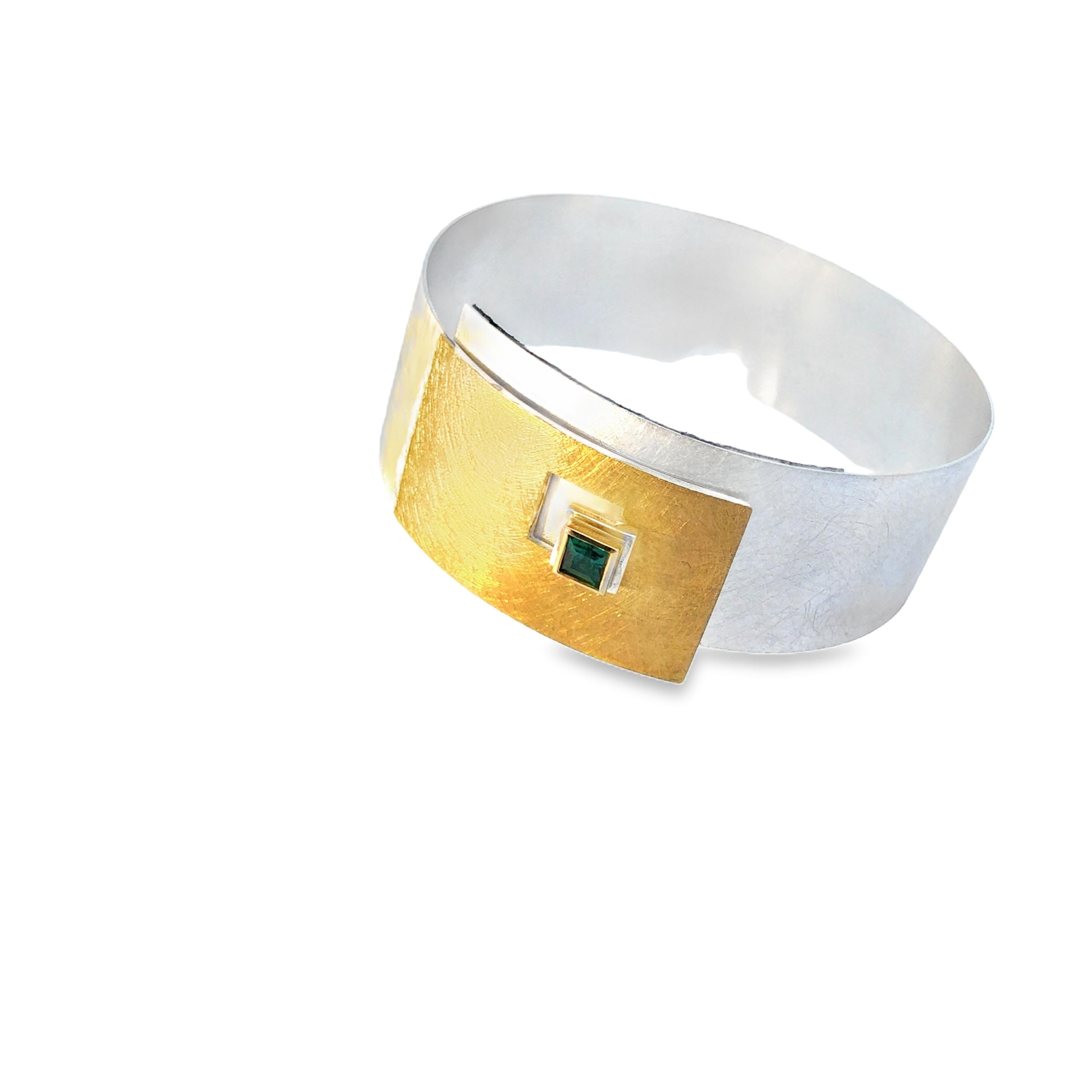 Der Armreif Modellnummer 1-20731 besteht aus Silber 925, Gold 900 und Gold 750, verziert mit einem carrégeschliffenen Turmalin von 0,32 ct. Optimal zur Geltung kommt der Armreif als elegantes Accessoire zu Abend- oder Büro-Outfits. Ein stilvoller Hingucker an jedem Handgelenk. Perfekt für besondere Anlässe oder als edles Alltagsstück geeignet.