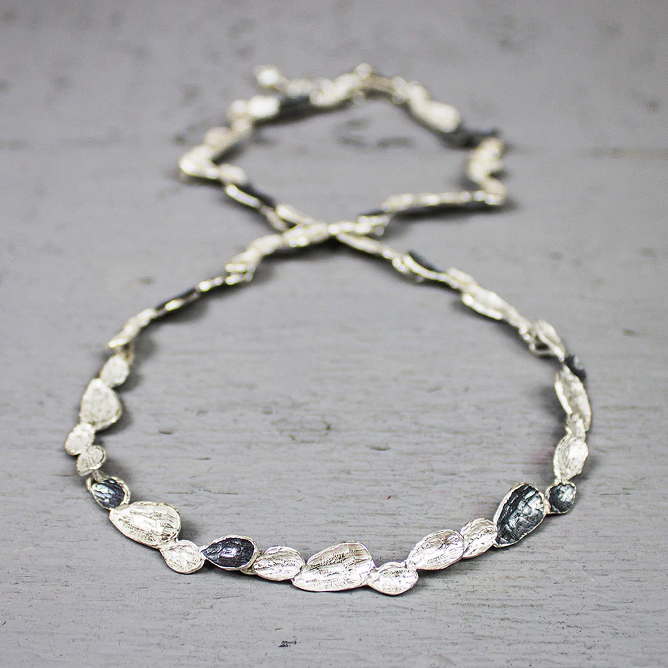 Dit bijzondere collier van het merk J&eacute;h Jewels bestaat uit glanzende zilveren druppelvormen (925-sterling zilver) en  donkere druppelvormen (geoxideerd zilver) die samen een geheel vormen.