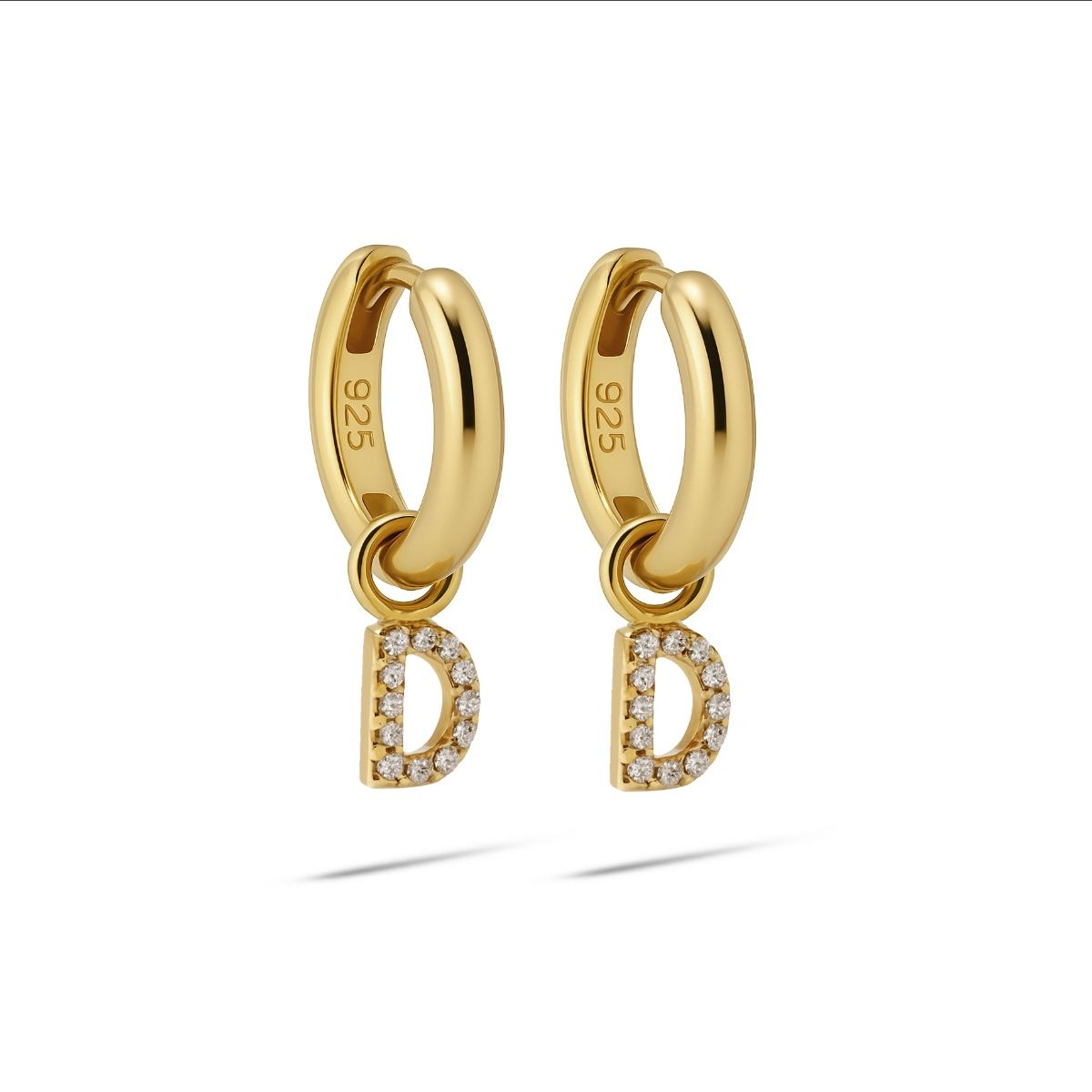 De Karma Hinged Hoops Zirconia Letter D Goldplated met modelnummer A178GP-D zijn stijlvolle creolen. Ze zijn verguld en versierd met zirkonia's voor een elegante uitstraling. Ideaal om dagelijks te dragen of tijdens speciale gelegenheden voor een persoonlijke touch. Combineer met andere gouden sieraden voor een complete look.