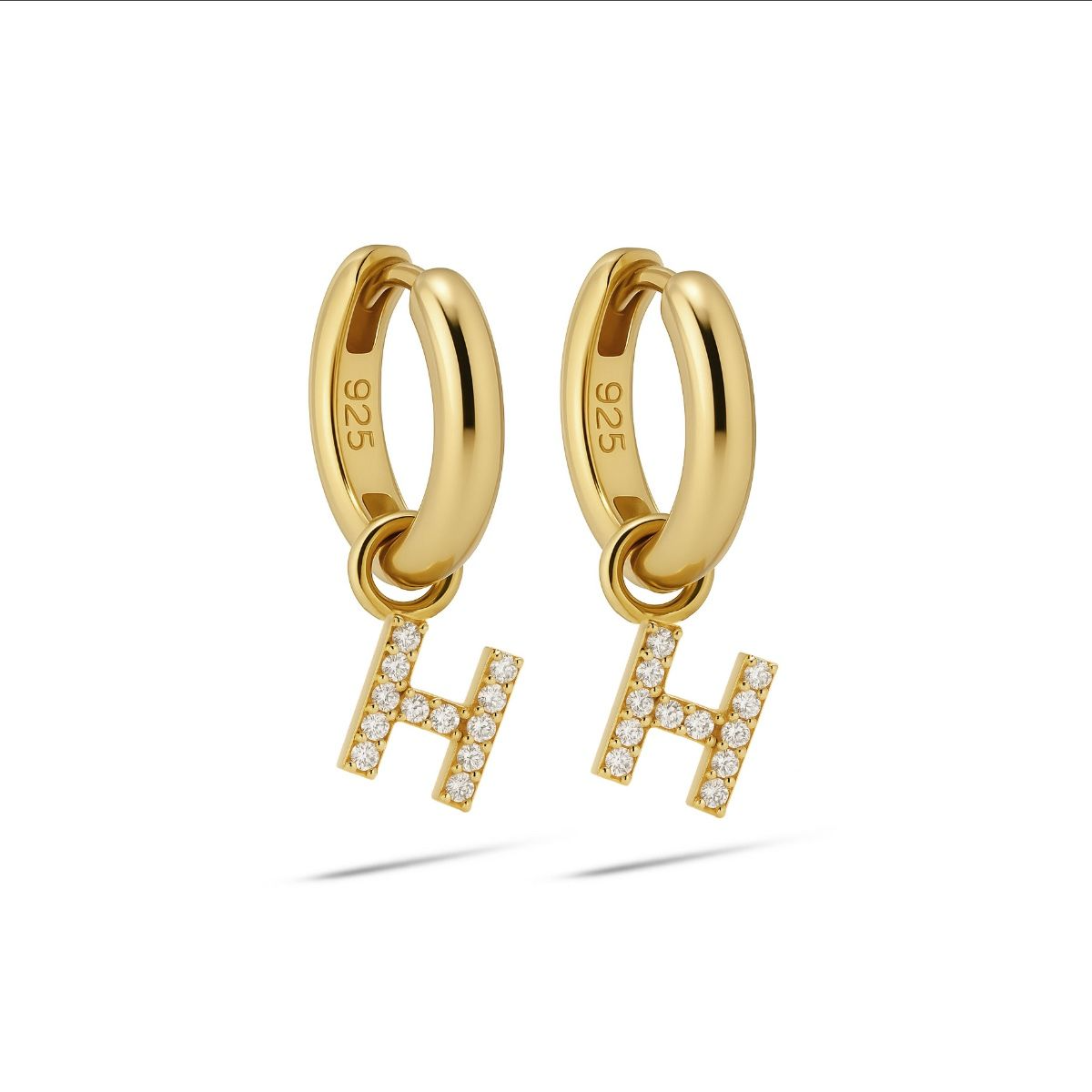 De Karma Hinged Hoops Zirconia Letter H Goldplated, modelnummer A178GP-H, zijn schitterende creolen versierd met zirkonia en een vergulde 'H'. Combineer ze met andere gouden sieraden voor een elegante look. Perfect voor wie een persoonlijk tintje aan hun stijl wil geven.