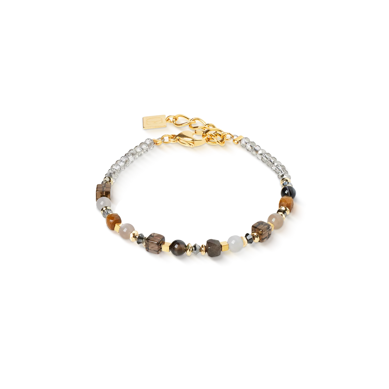 De Shape Mix Spikes Smoky Glow armband combineert de elegante kleuren van tijgeroog, rookkwarts, chocolademaansteen, agaat en gestreepte onyx met de sprankelende reflecties van Swarovski&reg;-kristallen. Verguld roestvrij staal zorgt voor moderne accenten en een elegante afwerking. De harmonieuze wisselwerking van warme bruine tinten maakt deze armband tot een veelzijdig accessoire dat elke look verfraait - van elegant tot casual.