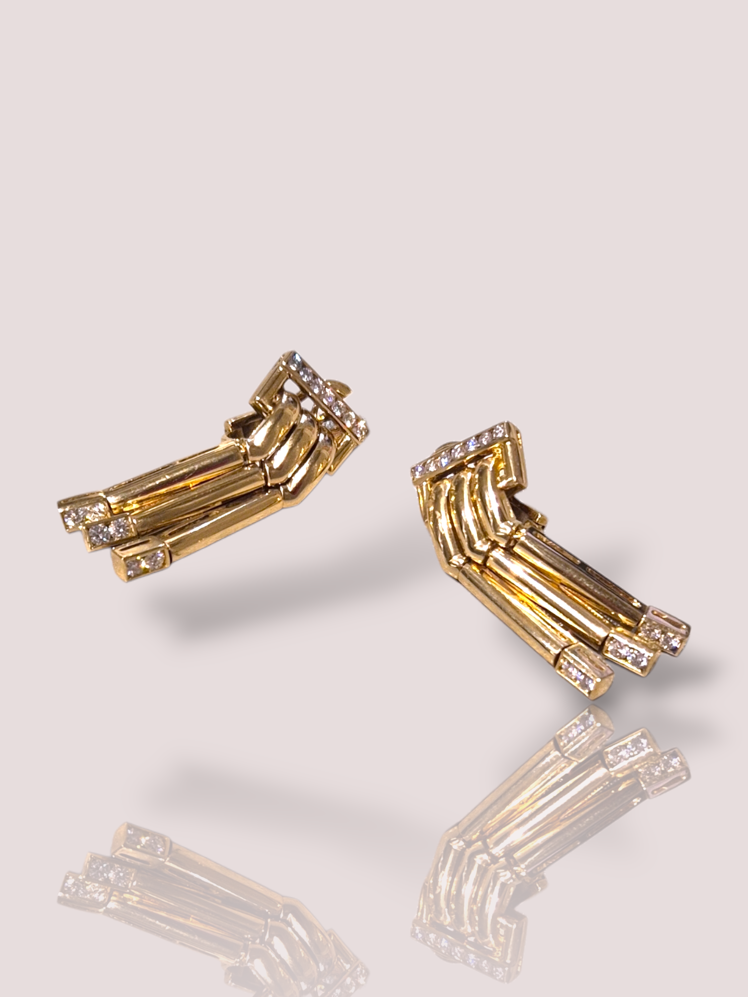 Deze fantastische unieke retro oorbellen van 18k geel goud zijn bezet met schitterende diamanten. Ze zijn prachtig gemaakt en wegen elk circa 12 gram! Draag ze bij formele evenementen of speciale gelegenheden om een elegante en tijdloze uitstraling te geven. Perfect om elke outfit mee op te fleuren!

De oorbellen hebben 3 hangende delen die bewegen bij het dragen. De onderkant bevat aan elk staafje 2 briljanten van 0,045ct en aan de bovenzijde bevat elke oorbel 7 briljant geslepen diamanten van elk 0,025ct. In totaal bevatten de oorbellen dus 0,89ct aan diamant! De oorbellen hebben een lengte van 4 cm.