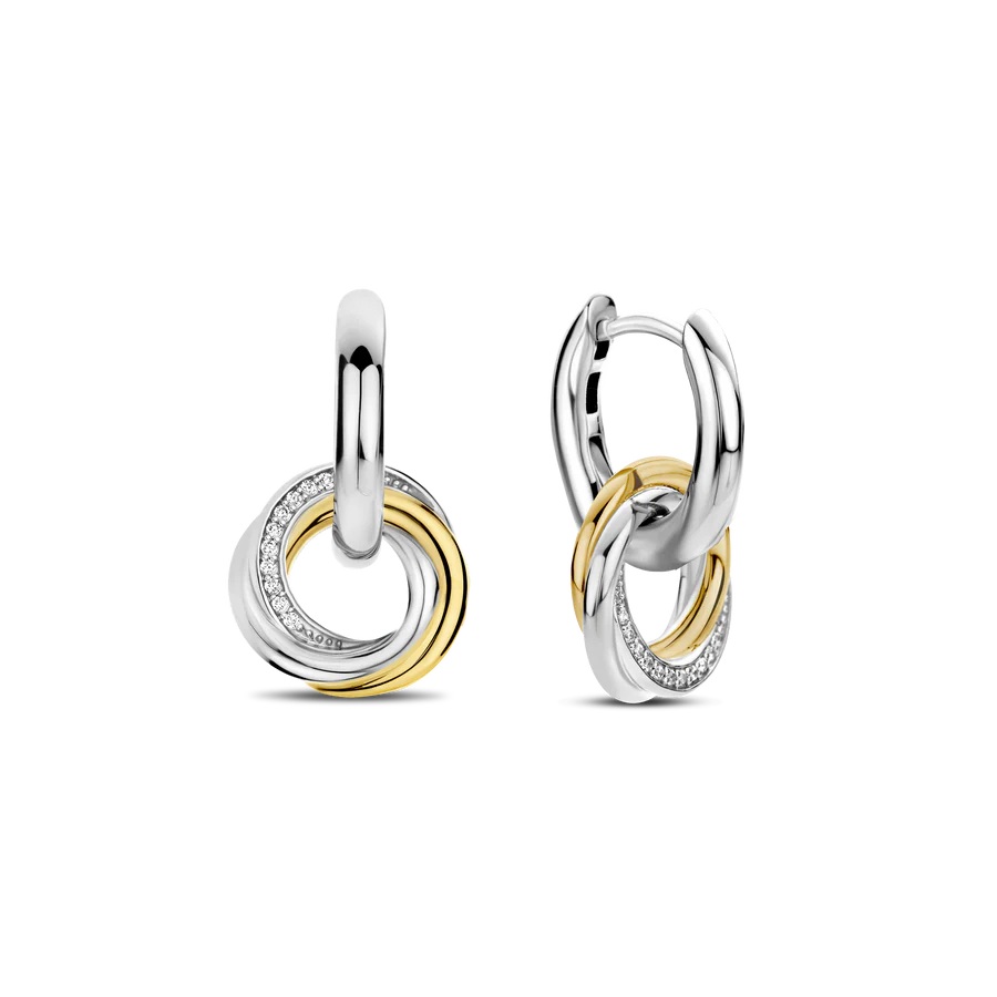 Ontdek een betoverend spel van texturen en metalen met deze TI SENTO gold-plated silver Earrings 7976ZY. Gemaakt van 925 sterling zilver en verzilverd voor blijvende schittering, hebben deze oorbellen twee slanke zilveren hoepels versierd met verfijnde verweven cirkelcharms. De charms pronken met stralende geelgoudkleurig-plating, schitterende pave en zilver. Deze kunstzinnig verweven stukken belichamen de perfecte mix van kunst en ontwerp, en vangen de essentie van tijdloze chic met een hedendaagse rand. Voeg een vleugje moeiteloze charme toe aan je oren met deze verbluffende stukken. Draag ze alleen voor een minimalistische uitspraak of gelaagd met andere TI SENTO oorbellen voor een gepersonaliseerde touch die vertrouwen en aantrekkingskracht uitstraalt. Met zorg vervaardigd voor gevoelige huid, zorgen deze nikkelvrije en hypoallergene oorbellen voor langdurig comfort en kwaliteit.