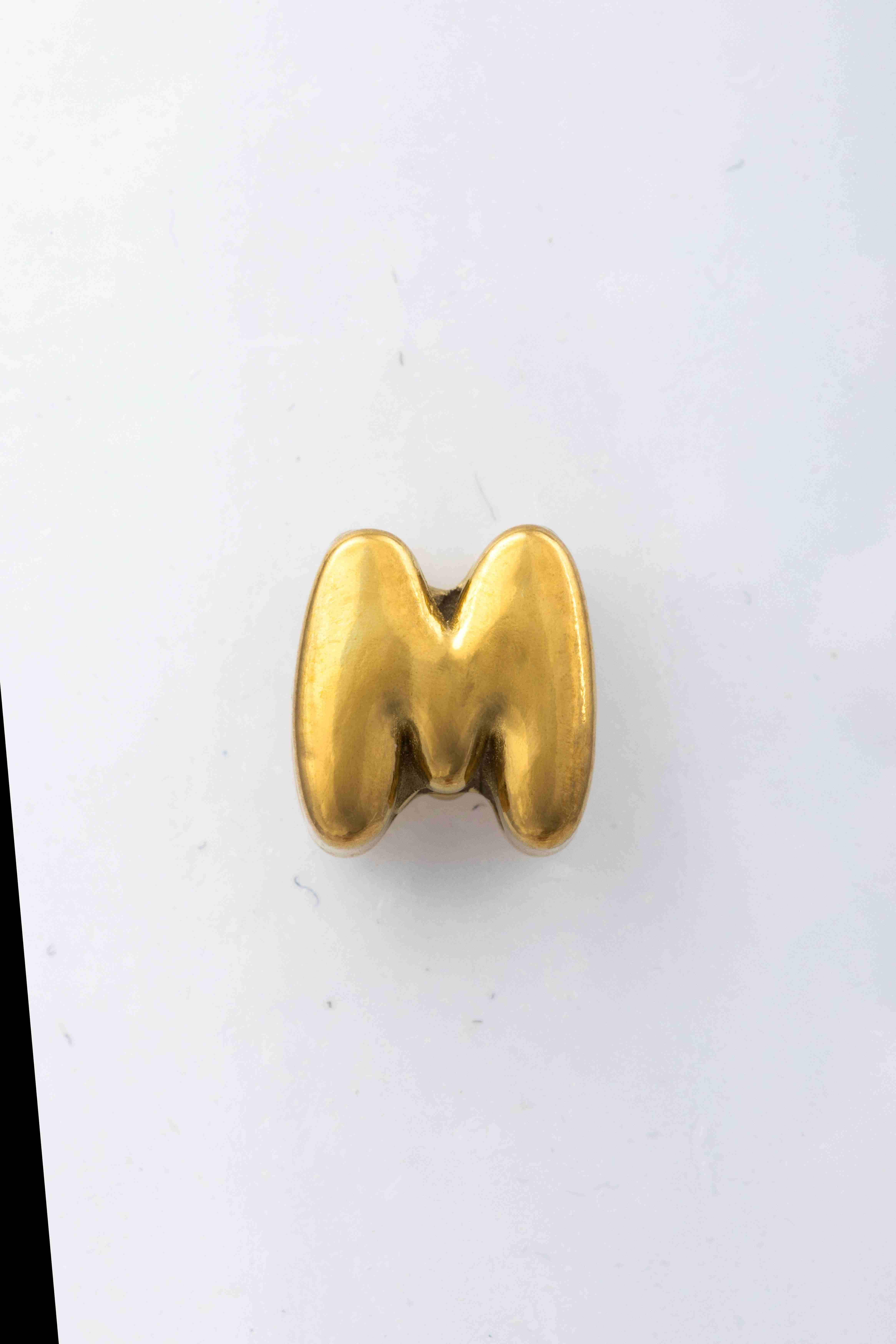 Der "ccgom Blumenkind Buchstabe 'M' Edelstahl gelb" Anh&auml;nger, Modellnummer CCGOM, besticht durch sein elegantes Design. Hergestellt aus rostfreiem Stahl, geh&ouml;rt er zur Kategorie Schmuck und ist ein Buchstaben-Anh&auml;nger. Tragen Sie ihn an einer feinen Kette als stilvolles Accessoire zu jedem Outfit. Perfekt f&uuml;r den t&auml;glichen Gebrauch oder besondere Anl&auml;sse.