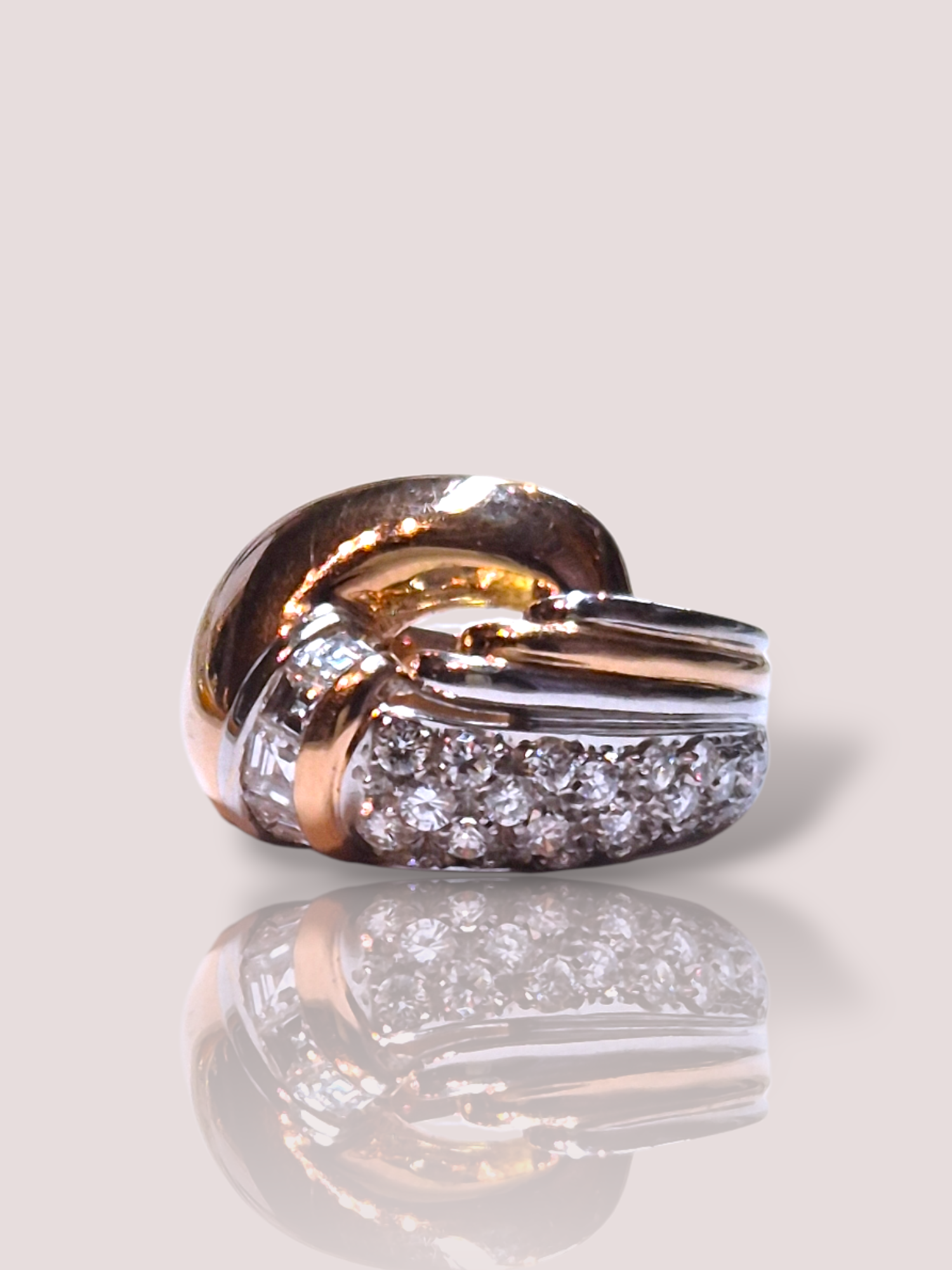 Deze vintage jaren '50 ring  is gemaakt van 18k wit en ros&eacute; goud en heeft schitterende diamanten. Het is een tijdloos sieraad dat zowel casual als bij speciale gelegenheden gedragen kan worden. Combineer met andere gouden accessoires voor een harmonieuze look. Ideaal voor liefhebbers van unieke, vintage stijl sieraden.

De ring weegt 13,65 gram en bevat ruim 1,5ct aan diamant, waaronder Asscher cut geslepen diamanten.