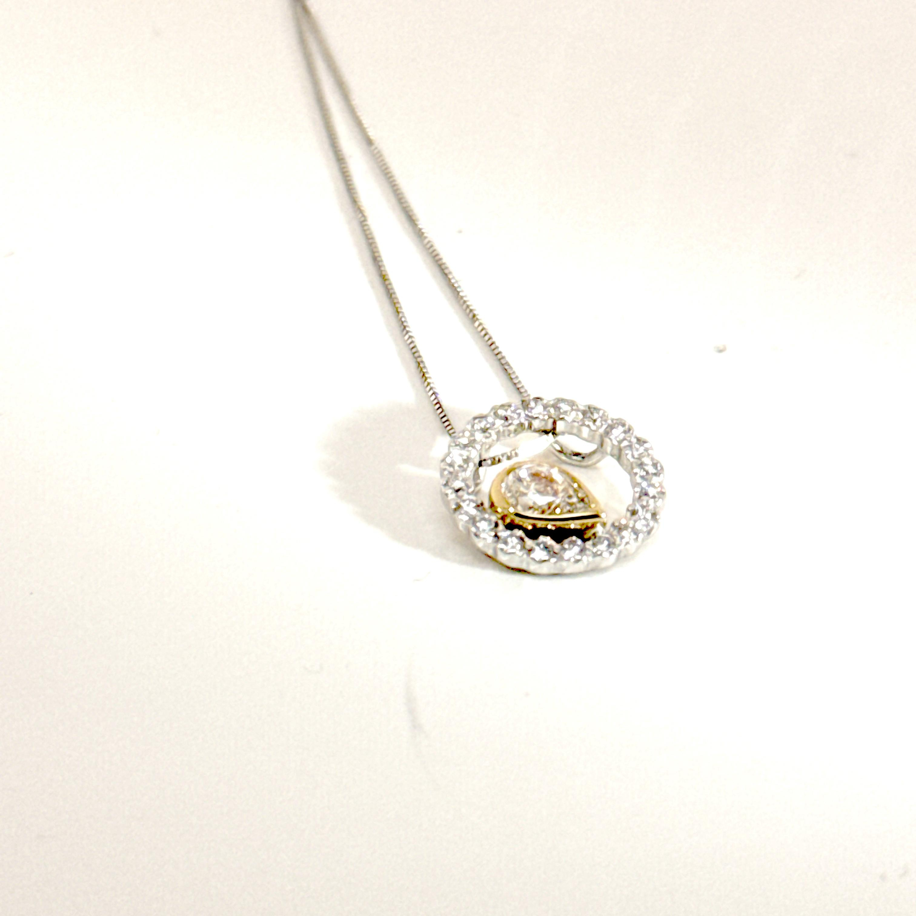 Hanger in 18 karaat geel en wit goud bezet met 0.30ct briljant centraal en 0.30ct briljant errond. 