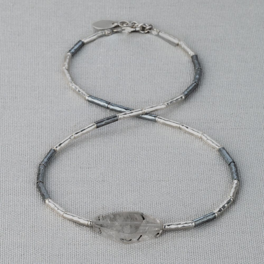 Collier gemaakt van 925 (geoxideerd) sterling zilveren buisjes. In het midden zit de edelsteen Rutielkwarts. Rutielkwarts is een opbeurende en kalmerende steen. Lees alles over deze edelsteen via onderstaande button! 
Combineer dit collier met een mooie armband, een ring en oorsieraden!