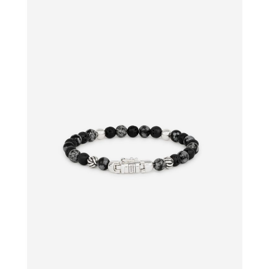 De Spirit Bead Mini Snowflake armband is ge&iuml;nspireerd op bidkralen en vertaald naar een uniek ontwerp van Buddha to Buddha, met het herkenbare gerecyclede sterling zilveren slot. De mini-spirit kralen zijn kleiner dan die van de Spirit Bead armbanden. Deze armband is vervaardigd met zwarte lavastenen afgewisseld met sneeuwvlok-obsidiaanstenen. Obsidiaan brengt balans in lichaam en geest, terwijl lavastenen de emoties kalmeren. Dit sieraad is ontworpen in Amsterdam en met de hand gemaakt in Zuidoost-Azi&euml;. In dit product smelten ethiek en esthetiek samen. Het is met de hand gemaakt van duurzame materialen die een leven lang meegaan.Let op: de sluiting van deze Spirit Bead armband bevat een magneet. Deze is niet roestvrij en daarom is het belangrijk om elk contact met water (zoals zwemmen en douchen, enz.) te vermijden om roestvorming rond de magneet te voorkomen.
