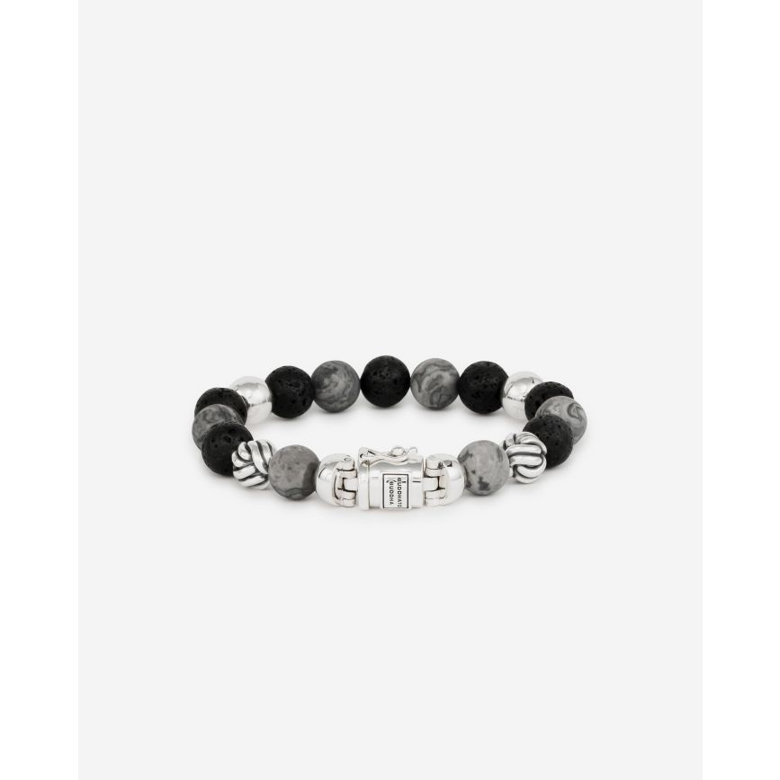 De Spirit Bead Mix armband, met grijze Picasso Jaspis-stenen en zwarte lavastenen, is ge&iuml;nspireerd op bidkralen en omgevormd tot een uniek Buddha to Buddha ontwerp met het herkenbare sterling zilveren slot. Kracht en esthetiek smelten samen in dit product. Handgemaakt met duurzame materialen om een leven lang mee te gaan. De jaspis biedt aarding en rust, terwijl de lavastenen emoties kalmeren. Handgemaakt en tijdloos, kan deze armband moeiteloos worden gecombineerd met leer en zilver. Ontworpen in Amsterdam, vervaardigd in Zuidoost Azi&euml;. Let op: de sluiting van deze Spirit Bead armband bevat een magneet. Deze is niet roestvrij en daarom is het belangrijk om elk contact met water (zoals zwemmen en douchen, enz.) te vermijden om roestvorming rond de magneet te voorkomen.