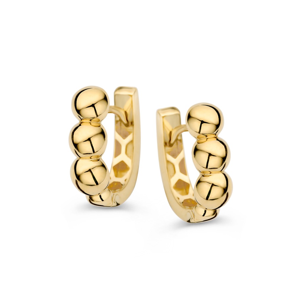 Opvallende, gouden oorringen aan de voorzijde bewerkt met een bolletjespatroon.
