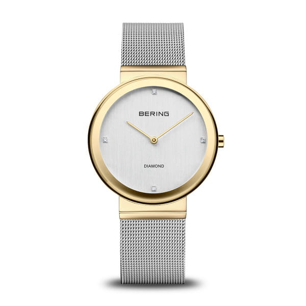  De BERING 10135-010 combineert strak minimalisme met een vleugje glamour. De glanzende goudkleurige kast vormt een elegant contrast met de zilverkleurige Milanese band &ndash; een subtiel bicolor-effect dat klasse en moderniteit uitstraalt. Op de geborstelde wijzerplaat fonkelen vier echte diamanten zachtjes in het licht.  Ge&iuml;nspireerd door de helderheid van het Noordpoolgebied, staat BERING voor tijdloze eenvoud. Met zijn ultradunne kast, krasbestendig saffierglas en betrouwbaar kwartsuurwerk is dit horloge perfect voor elke dag &ndash; en elke gelegenheid. 