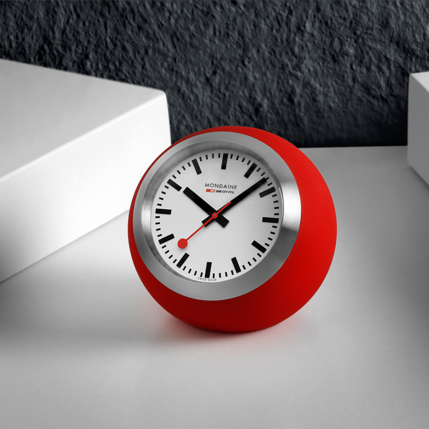 Mondaine Globe clock M660.30335.16SBP - Siliconen - Rood - 60mm
Ge&iuml;nspireerd door de helderheid van Zwitsers design en de tijdloze principes van Bauhaus, brengen onze nieuwe Globe Clocks moderne verfijning in elke ruimte. Met strakke lijnen, functionaliteit en een gedurfde vorm herdefinieert deze upgrade de tafelklok voor hedendaagse interieurs waar vorm en functie samenkomen en tijd een statement maakt. Deze rode siliconen klok heeft een witte wijzerplaat met zwarte uursaanduiding en als blikvanger de rode secondewijzer, net als de wel bekende stationsklok. Het klokje is Swiss Made, heeft een gehard mineraalglas, een doorsnee van 60mm en is 3ATM. 

Het Merk:
The Official Swiss Railway Watch. Gebaseerd op de offici&euml;le stationsklok van de Zwitserse spoorwegen, is 30 jaar geleden de horlogelijn onder het merk Mondaine opgezet. Zwitserse kwaliteitsuurwerken, net zo punctueel als de Zwitserse treinen. Een echte design klassieker met een unieke wijzerplaat en de wereldberoemde rode secondewijzer met bolletje. Herkenbaar uit duizenden.

Specificaties:
- Gehard mineraalglas
- Witte wijzerplaat
- Swiss Made
- 3ATM (Regen- & spatwaterdicht)
- 60mm
- Rode siliconen ronde kast