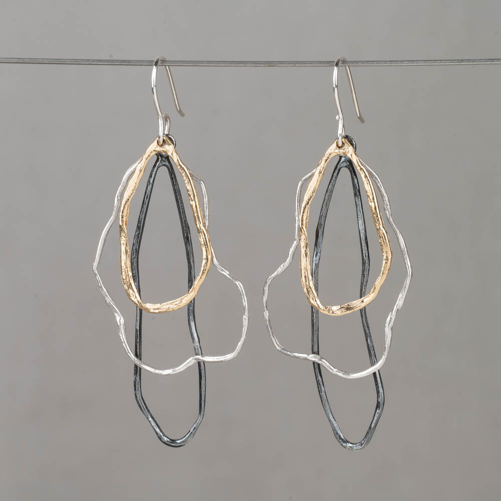 Oorhanger drie kleuren wolken trio is een speels en tegelijk verfijnd ontwerp waarin drie organische vormen sierlijk onder elkaar bewegen. De combinatie van 925 sterling zilver, geoxideerd zilver en zilver verguld zorgt voor een mooi kleurenspel. Het koele zilver, het donkere accent van het oxy en de warme vergulde vorm versterken elkaar op elegante wijze en geven de oorhangers diepte en karakter. Combineer met een mooi collier, een ring en armband voor een complete look!