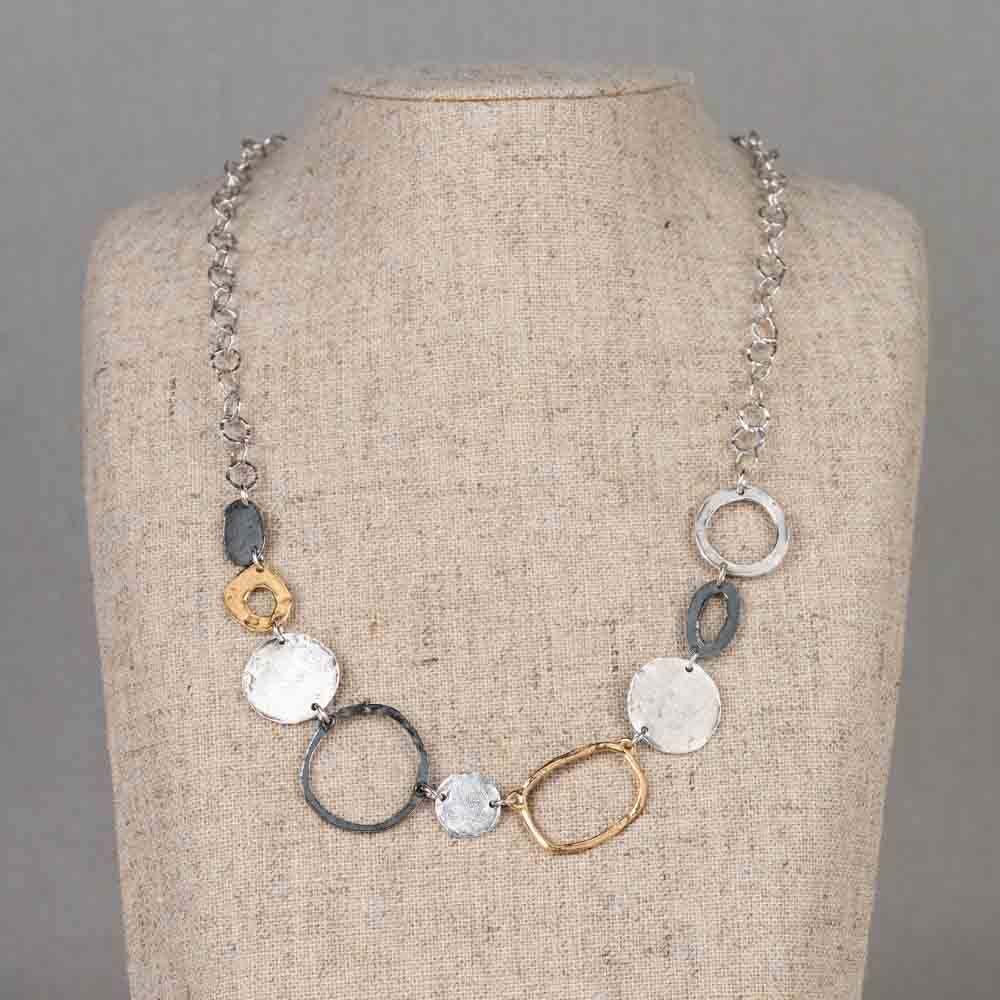 Dit collier is een mooie combinatie van organische vormen en subtiele contrasten. De verschillende schakels en cirkels vloeien speels in elkaar over. Dit collier valt prachtig om de hals. Vervaardigd van 925 sterling zilver, gecombineerd met geoxideerd zilver en verguld zilver, ontstaat een mooi kleurenspel. Het koele zilver, het donkere geoxideerde accent en de warme vergulde elementen versterken elkaar en geven het collier diepte en karakter. Combineer met een paar mooie oorbellen en een ring voor een complete look!